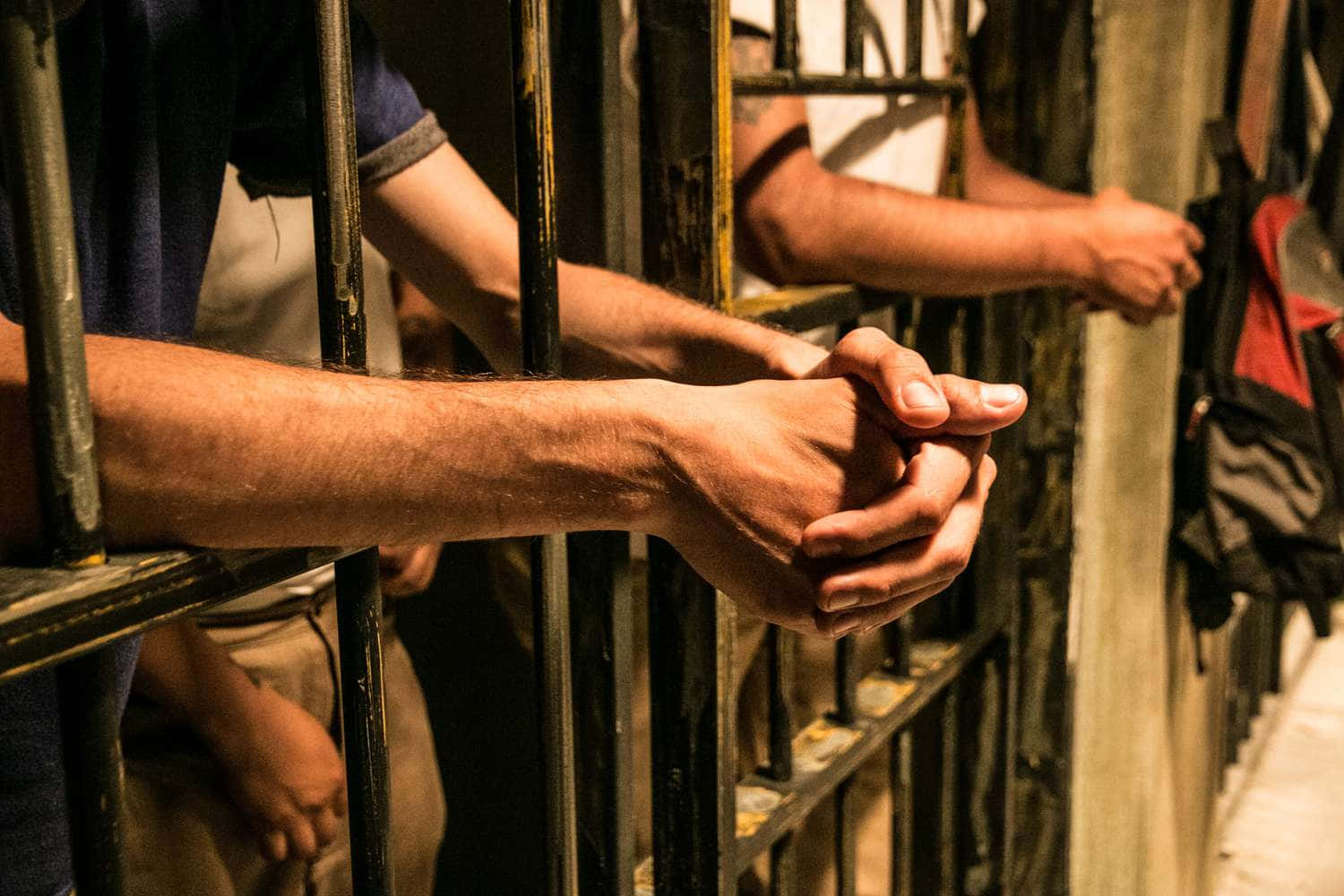 Inmates Clasping Hands Jail Bars Picture