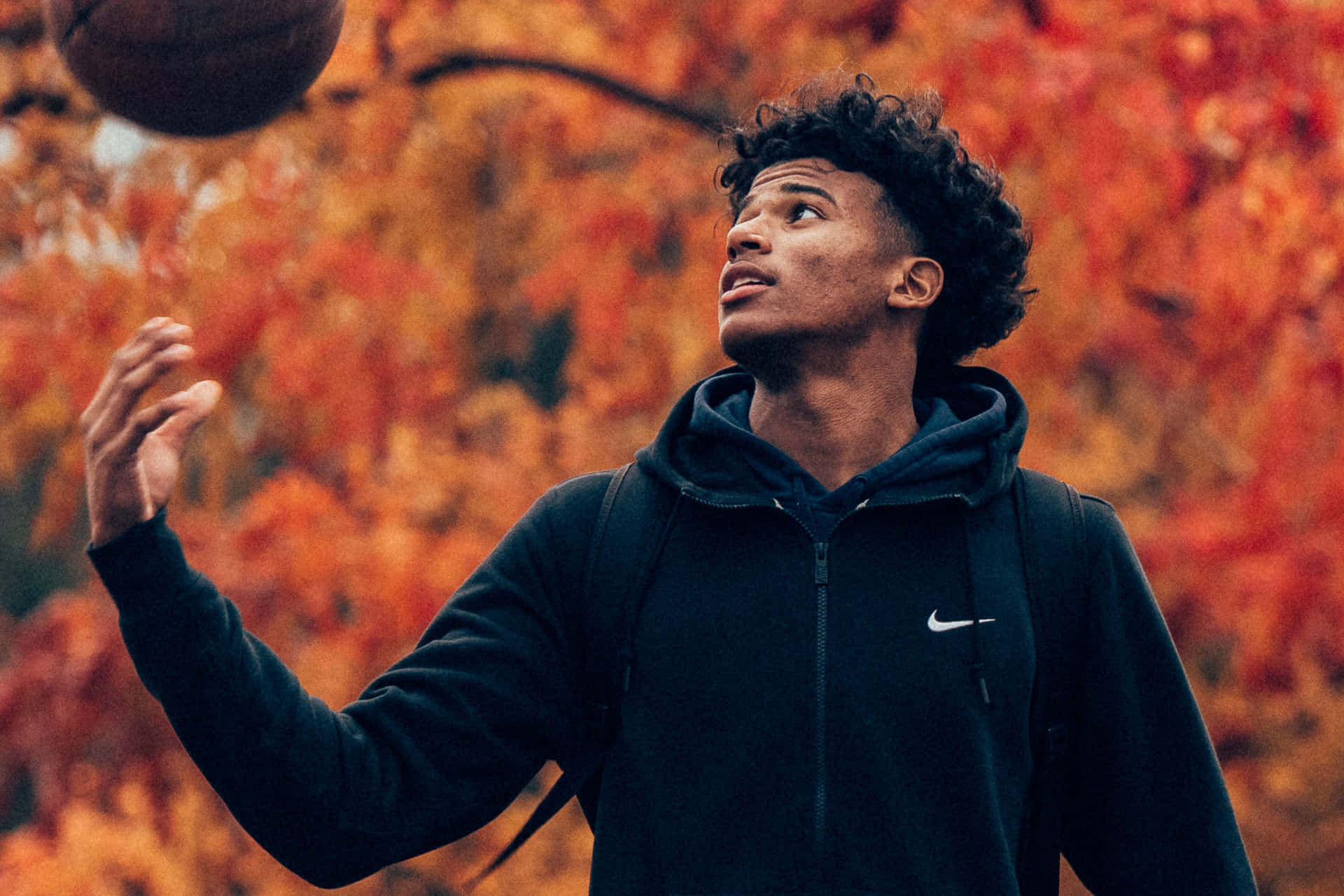 A Young Man Catching A Basketball Ball Wallpaper