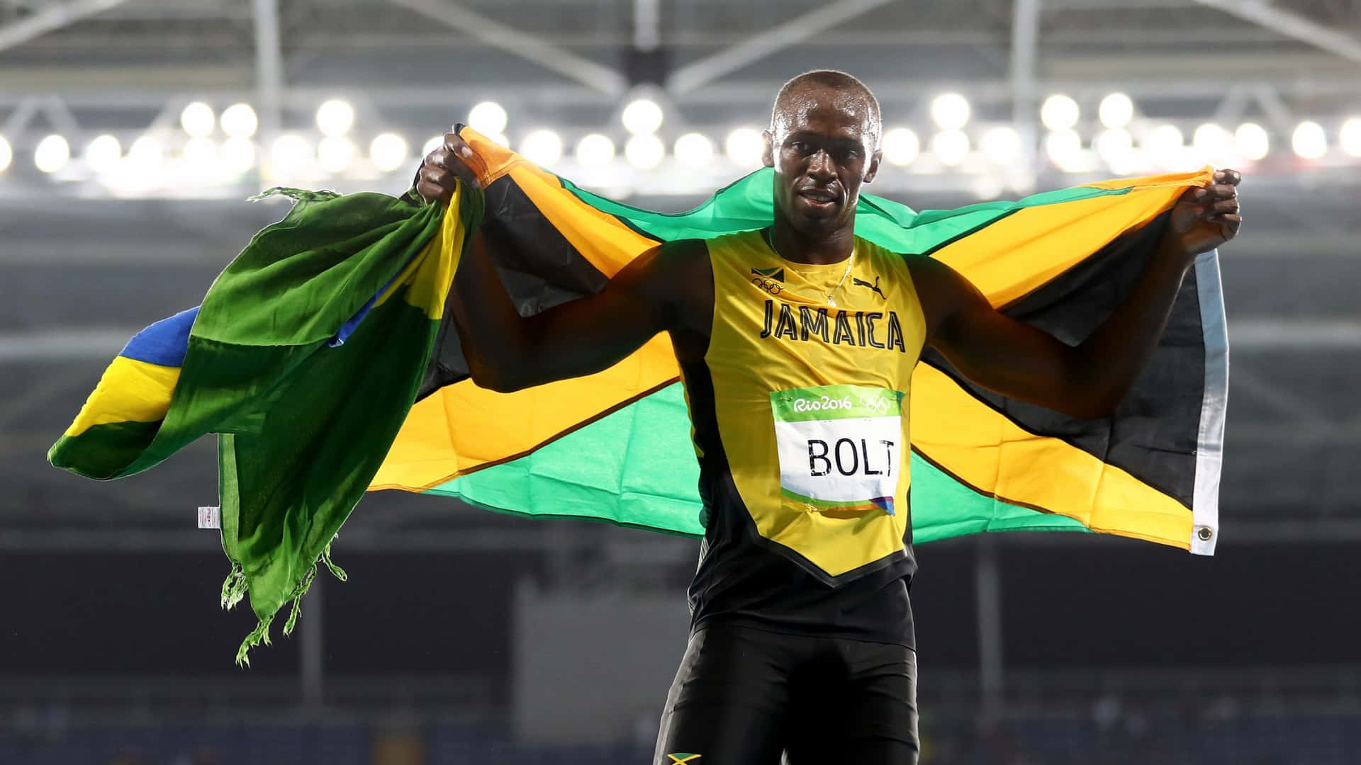 Jamaican Athlete Celebratingwith Flag Wallpaper