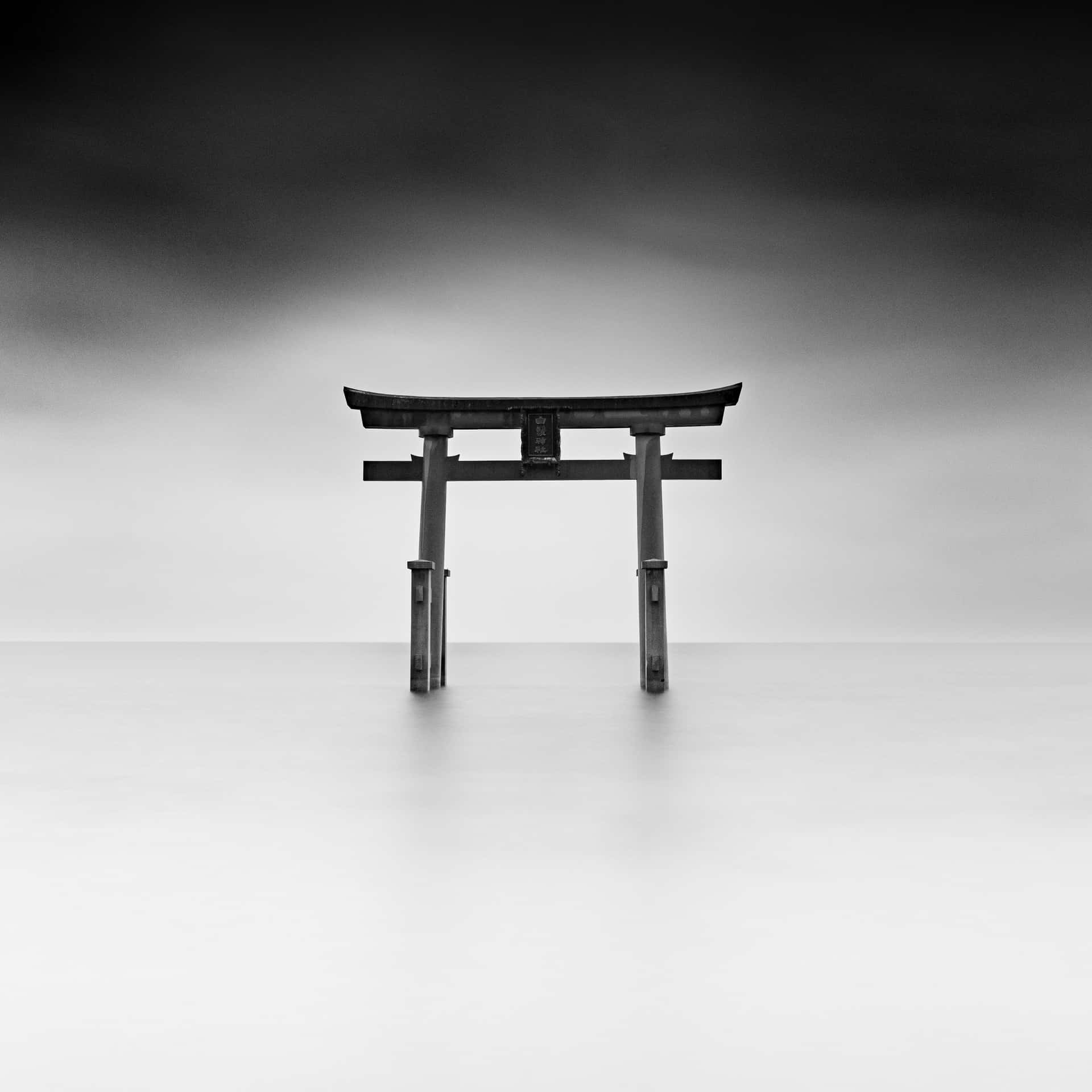 A Black And White Photo Of A Tori Gate In The Water Wallpaper