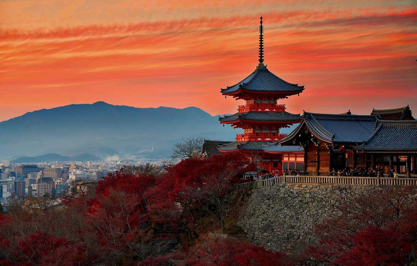 A Pagoda With Red Trees And Mountains In The Background