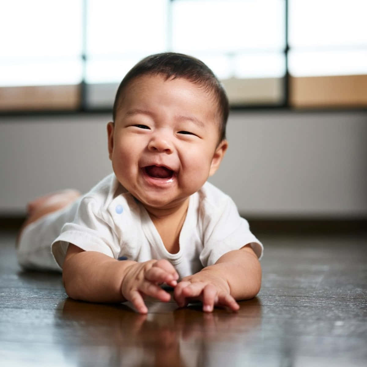 A Baby Is Laughing On The Floor