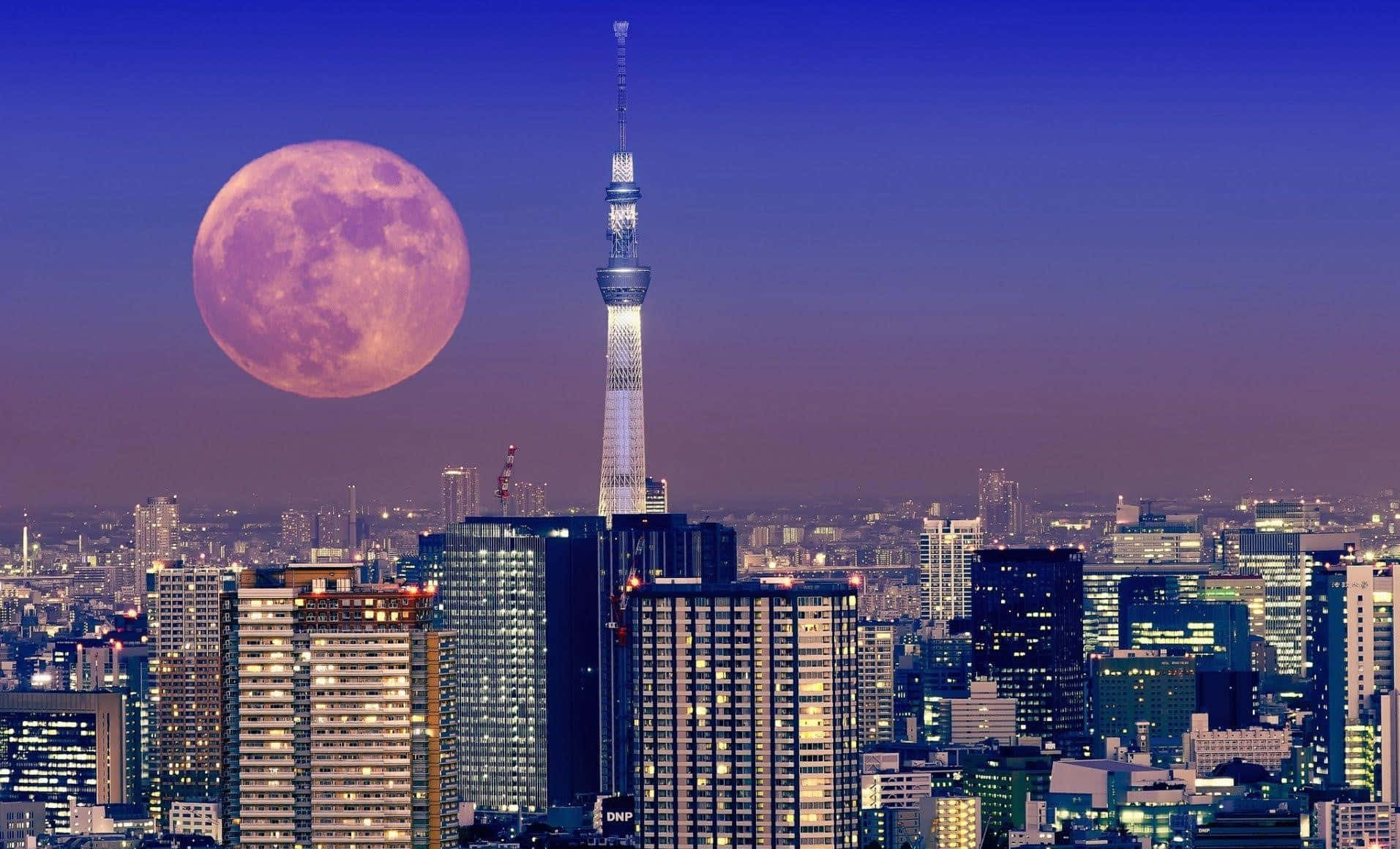 A Pink Moon Is Seen Over A City With Tall Buildings Wallpaper