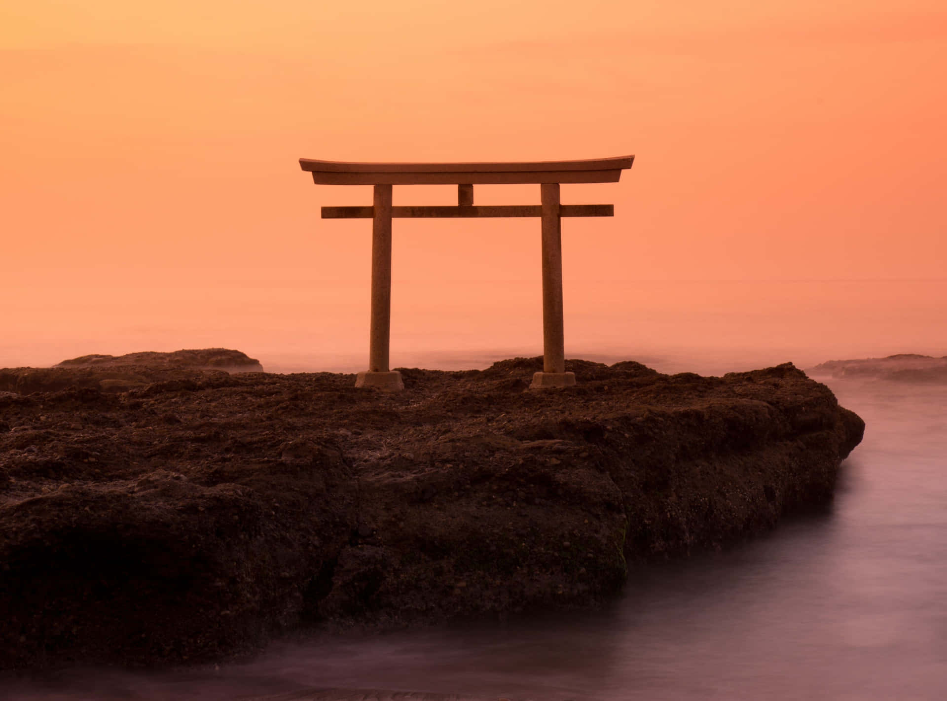 A Tori Gate Sits On A Rock In The Ocean Wallpaper