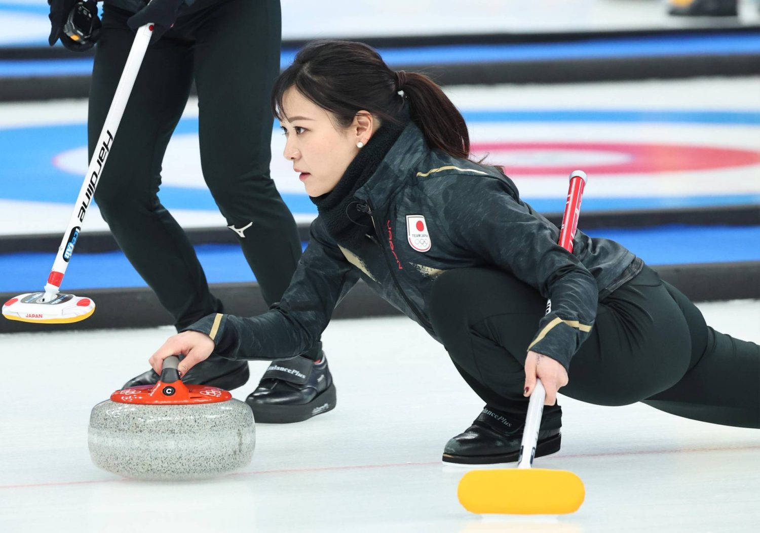 Equipede Curling Japonesa Em Treinamento. Papel de Parede