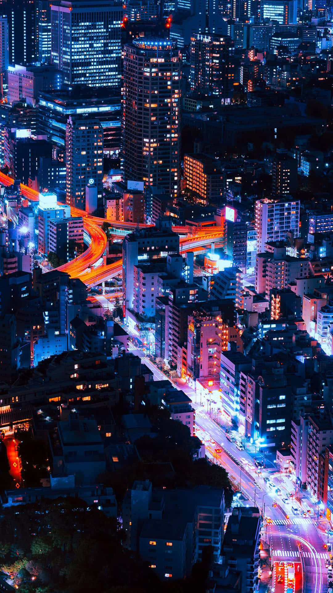 A City At Night With A Street And Buildings Wallpaper