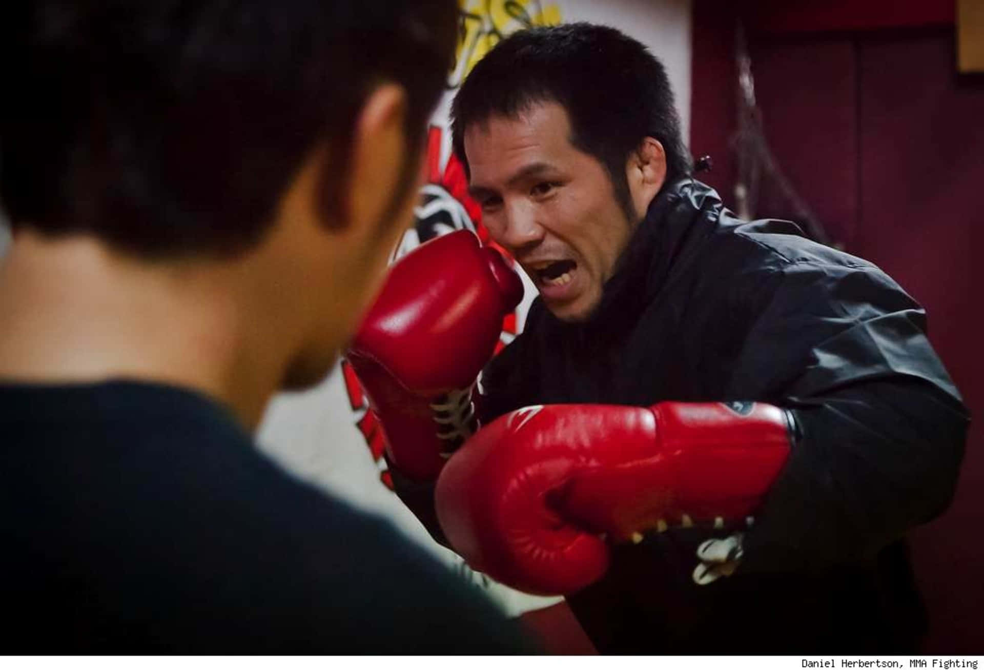 Luchadormixto Japonés Hayato Sakurai Atacando Con Golpes Fondo de pantalla