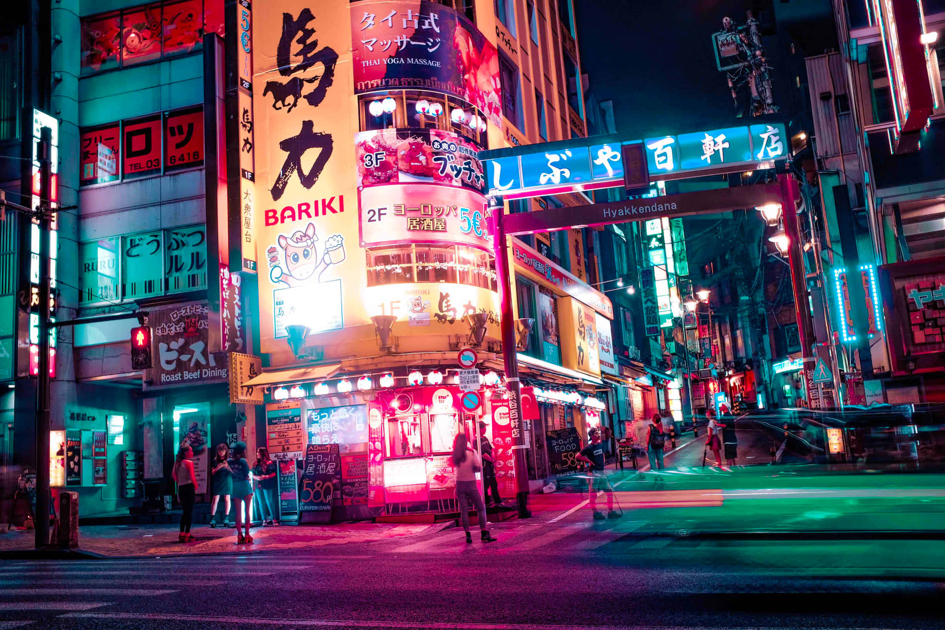 Et natskue af Tokyo belyst med japanske neon skilte. Wallpaper
