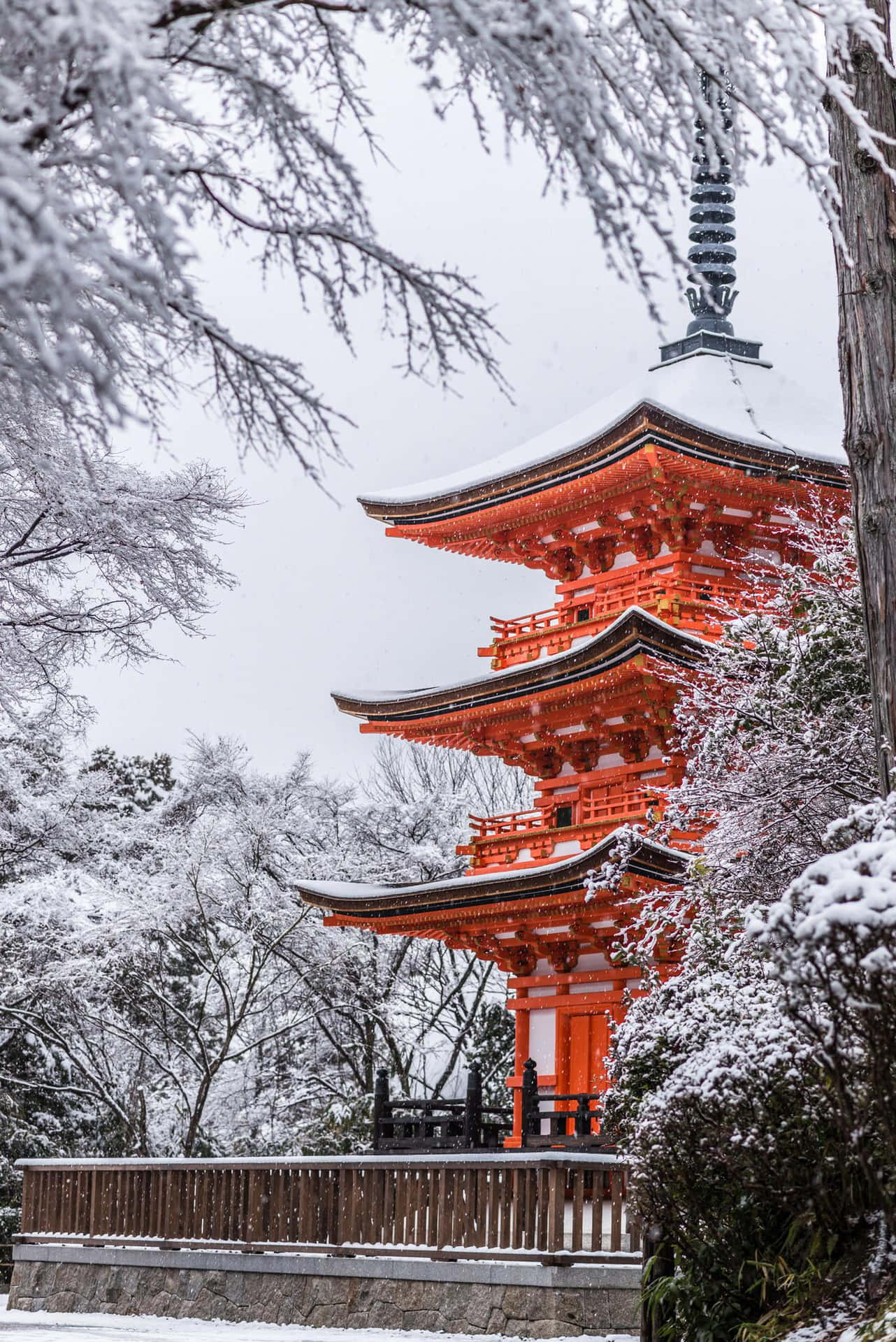 A Pagoda In The Snow With Trees Surrounding It Wallpaper