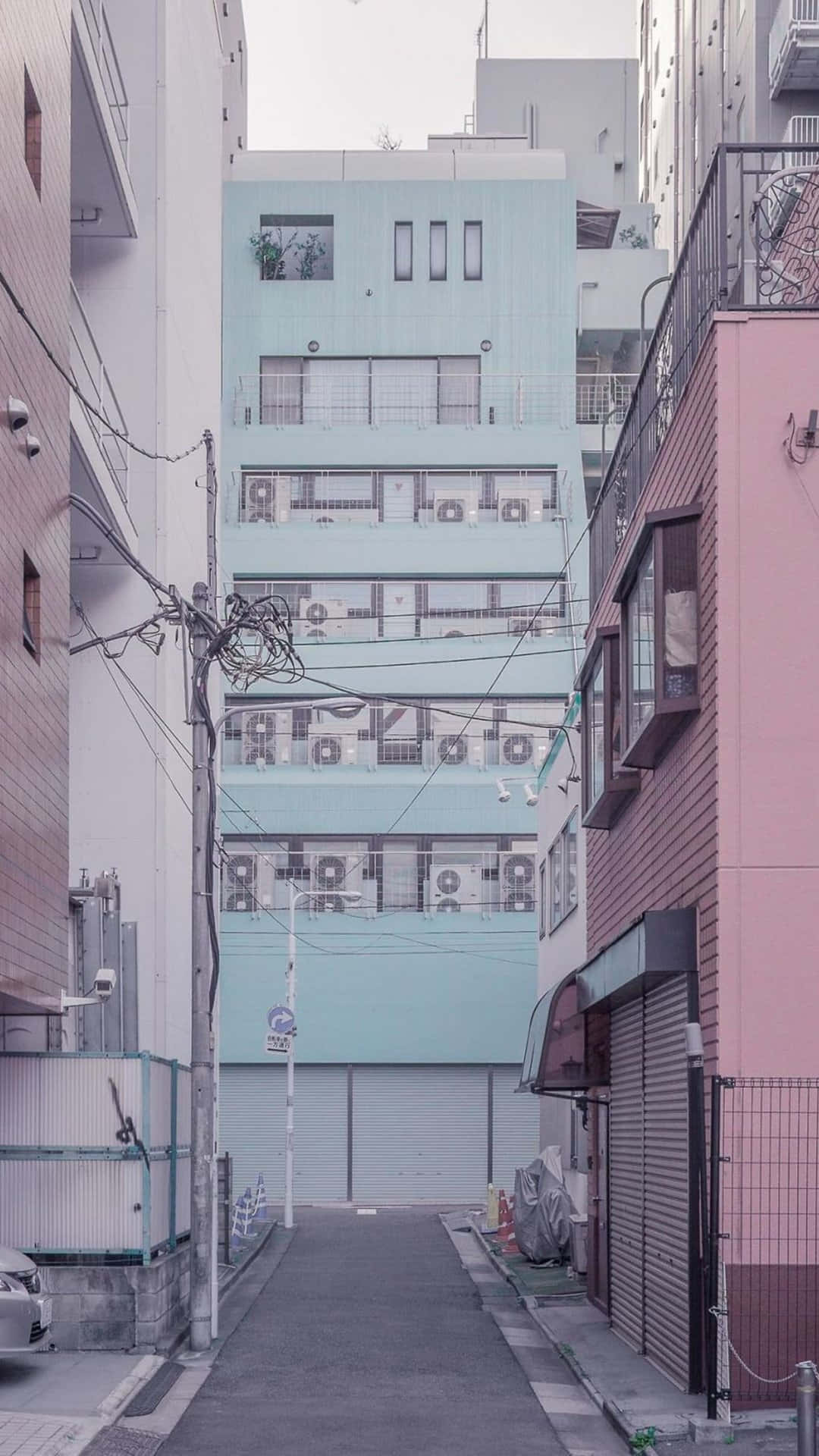 Edificiorosa En La Calle Japonesa Con Estacionamiento De Autos. Fondo de pantalla