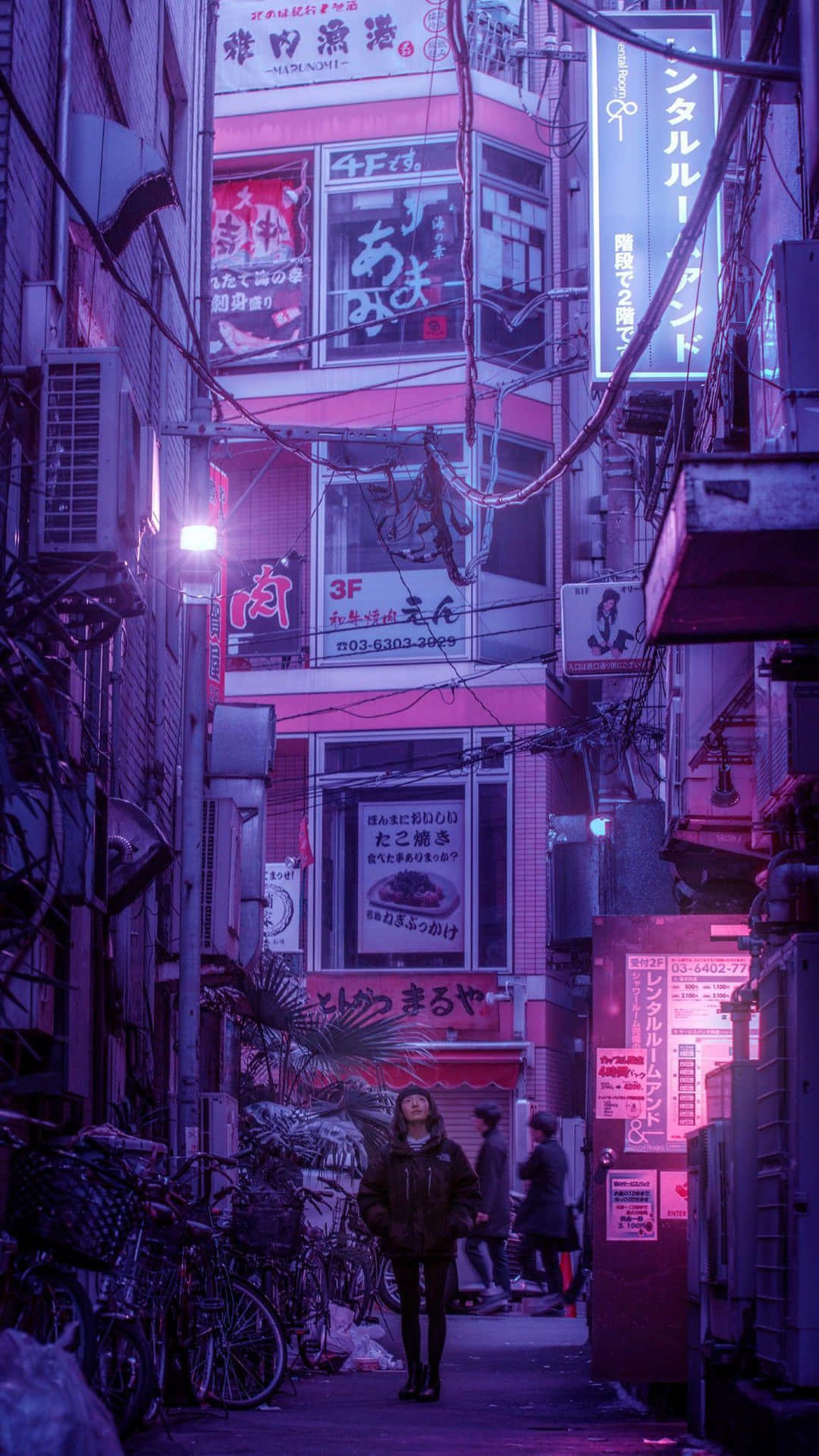 A Man Walking Down A Street At Night Wallpaper