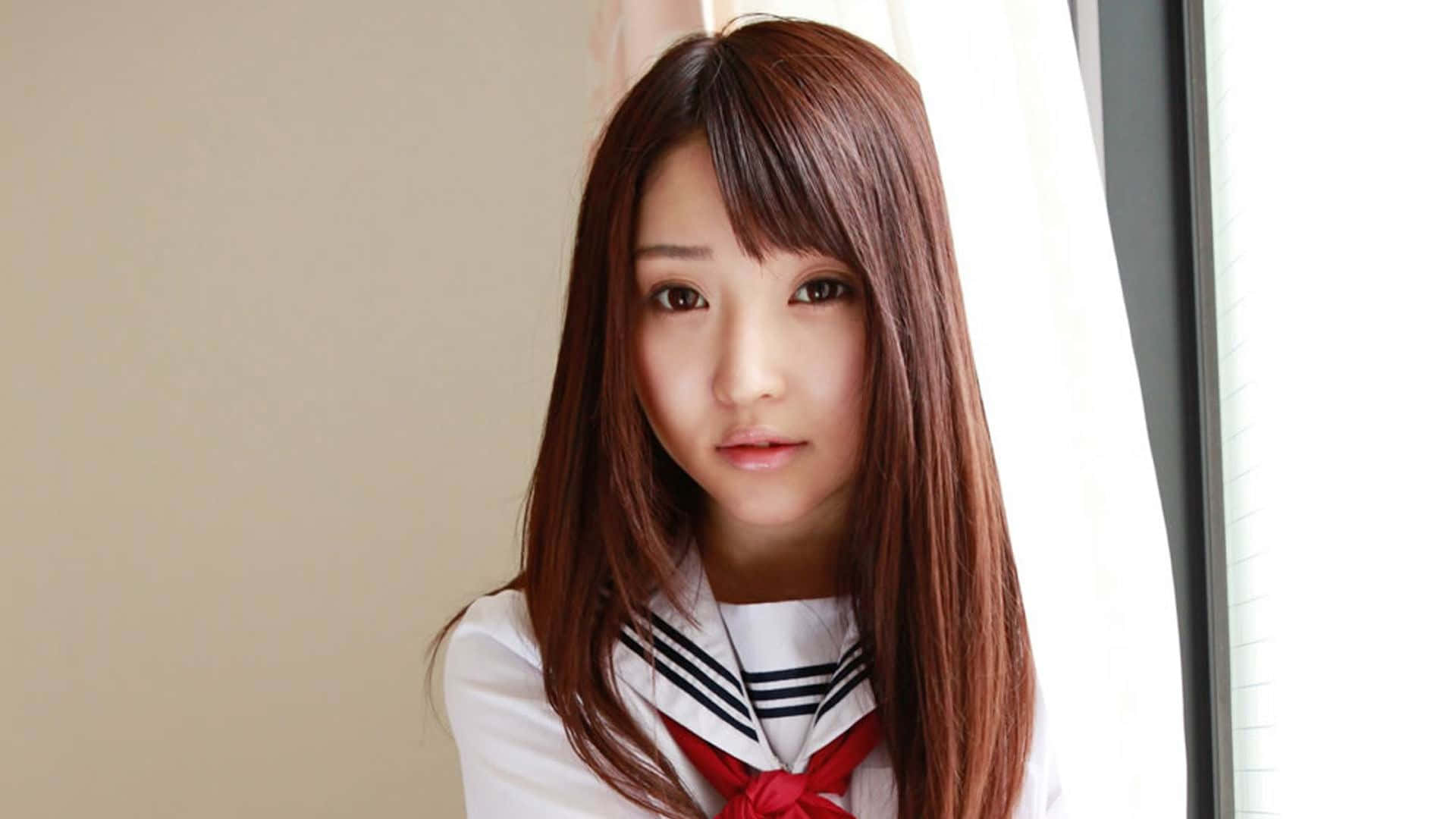 Japansk skolepige, der poserer til et skrivebordsbaggrund. Wallpaper