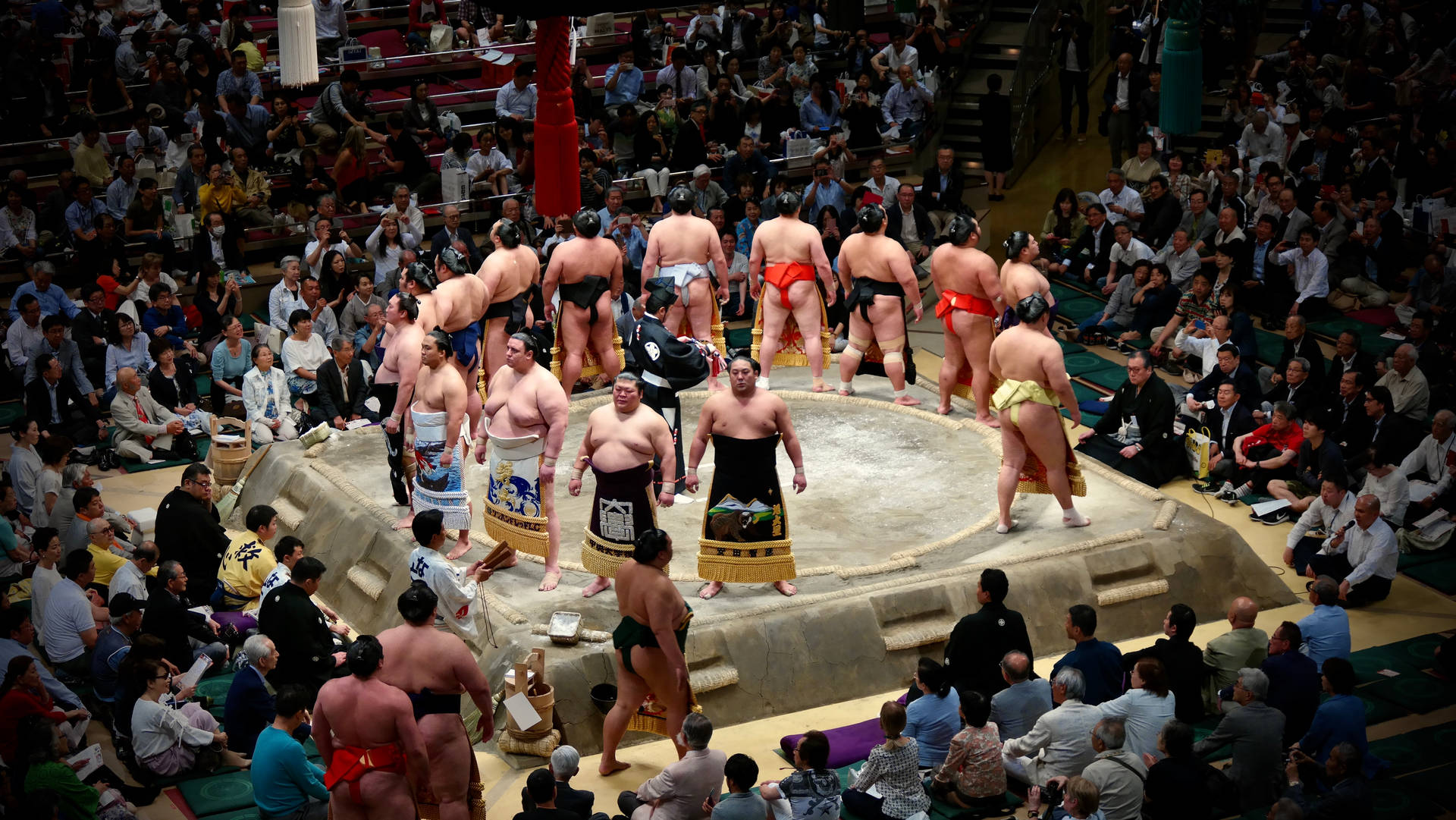 Two Sumo Wrestlers Clash in a Traditional Japanese Arena Wallpaper