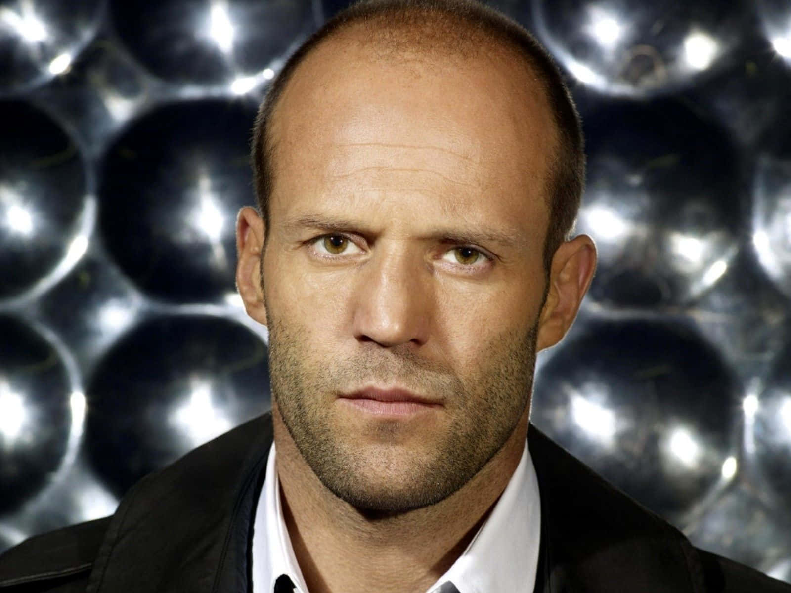 Jason Statham Exhibiting Confidence With His Iconic Bald Look Wallpaper