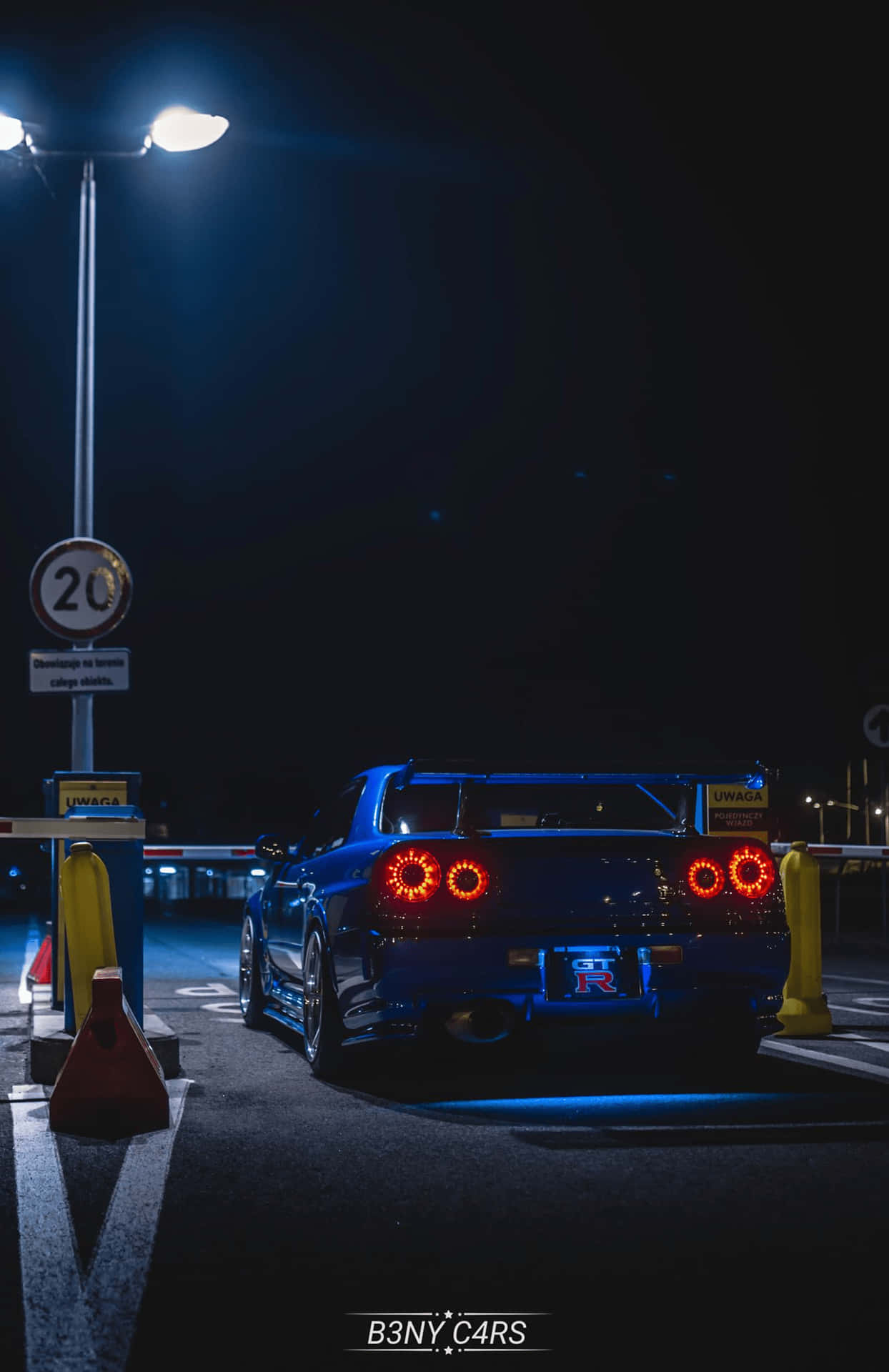 En blå sportsbil parkeret i et parkeringshus om natten. Wallpaper