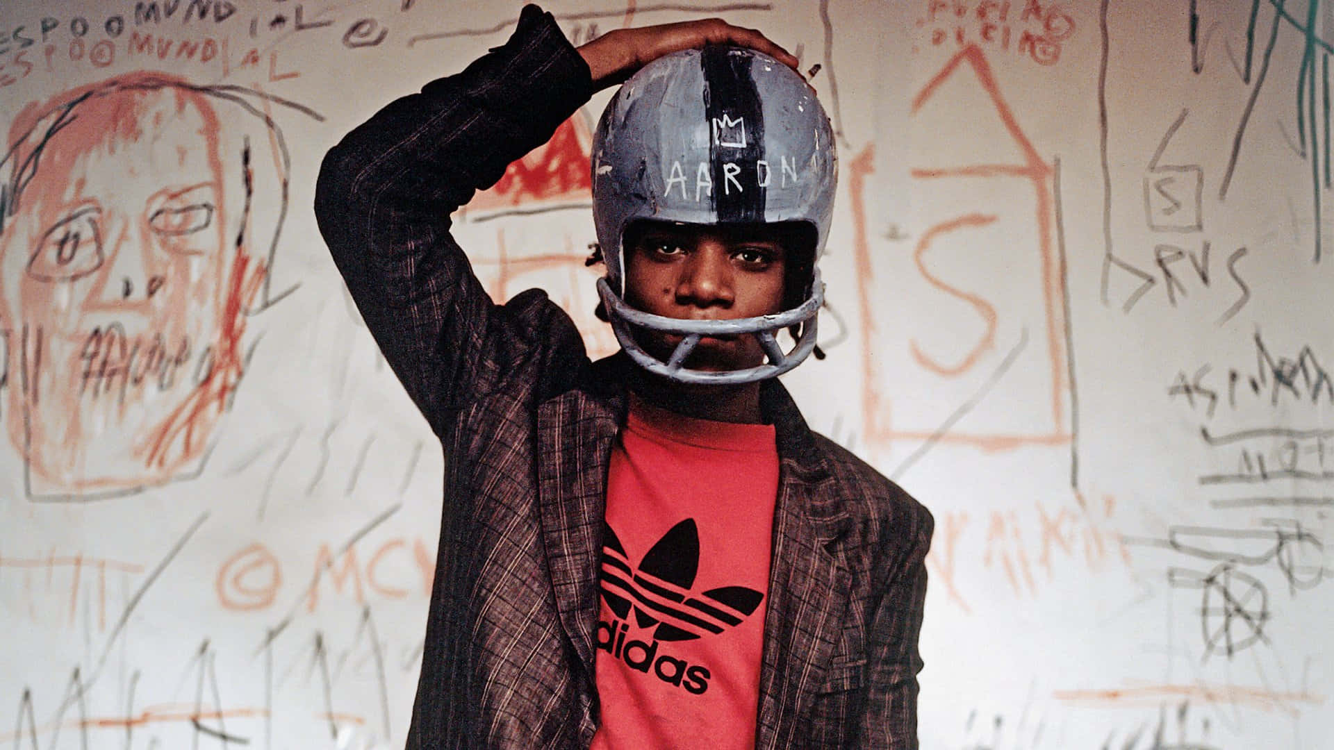 A Young Man Wearing A Helmet And Holding A Football Wallpaper