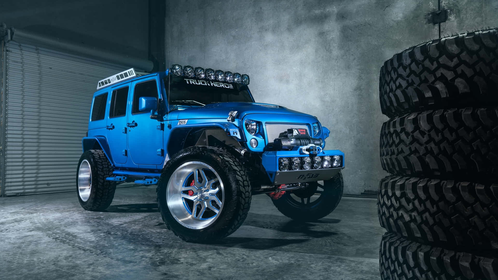 Einblauer Jeep Ist Vor Einem Reifen Geparkt.