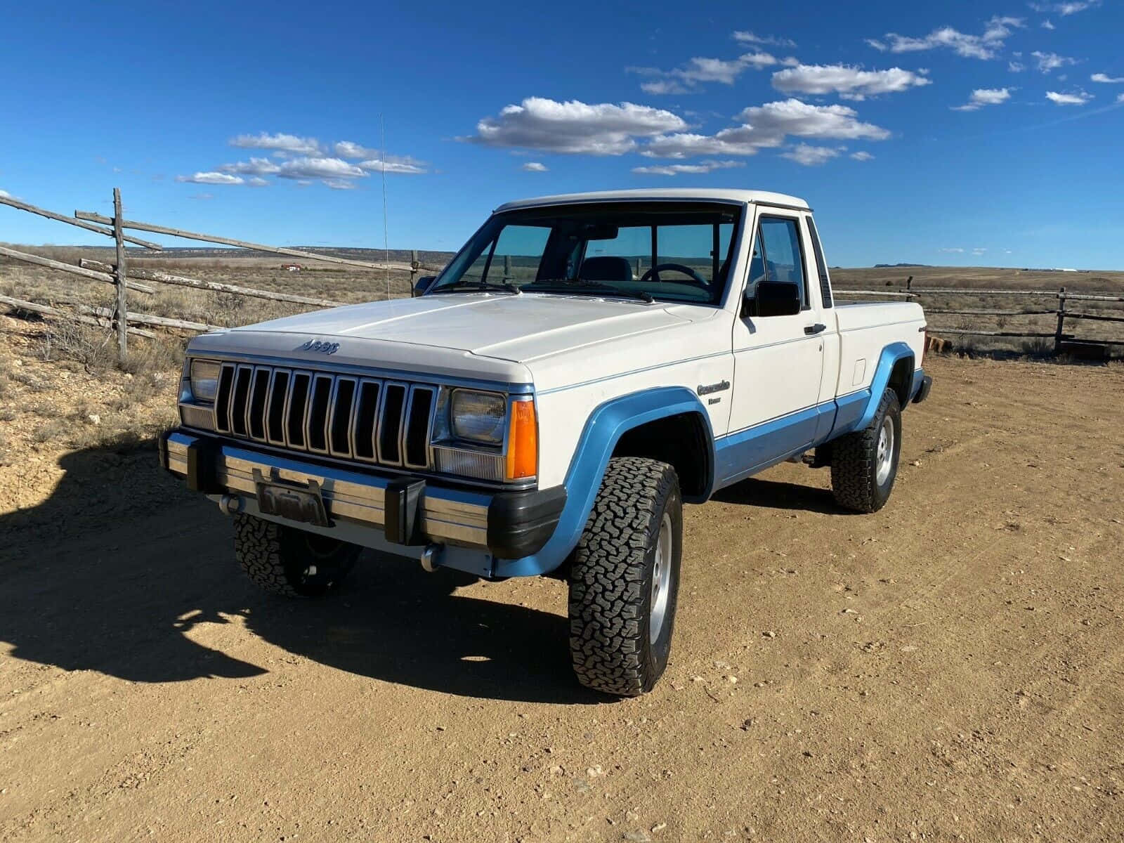 A stunning red Jeep Comanche off-roading in an epic adventure Wallpaper