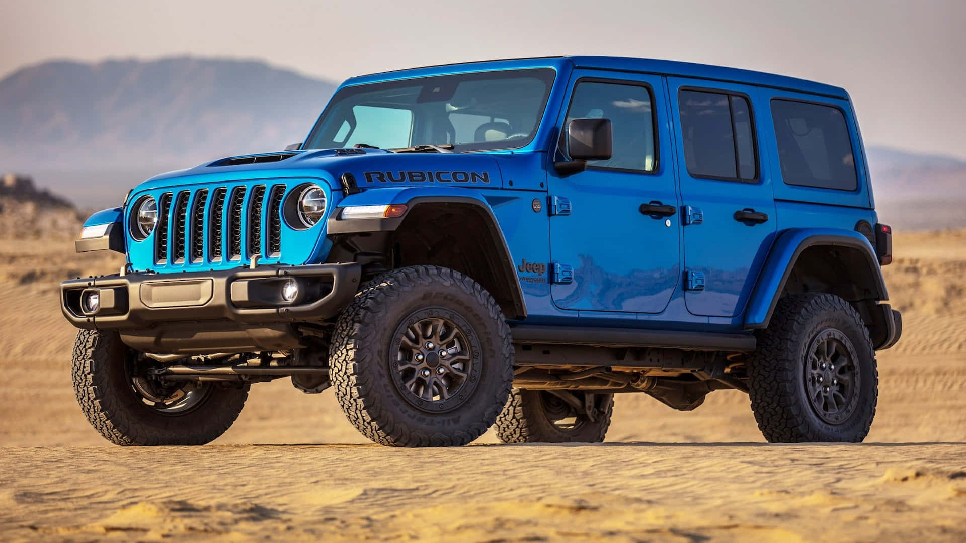 The Blue Jeep Wrangler Is Driving In The Desert
