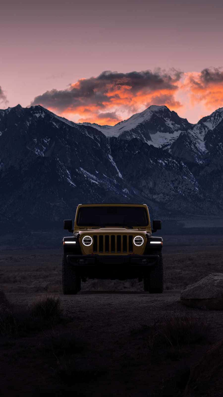 The Jeep Wrangler Is Parked In The Desert At Sunset