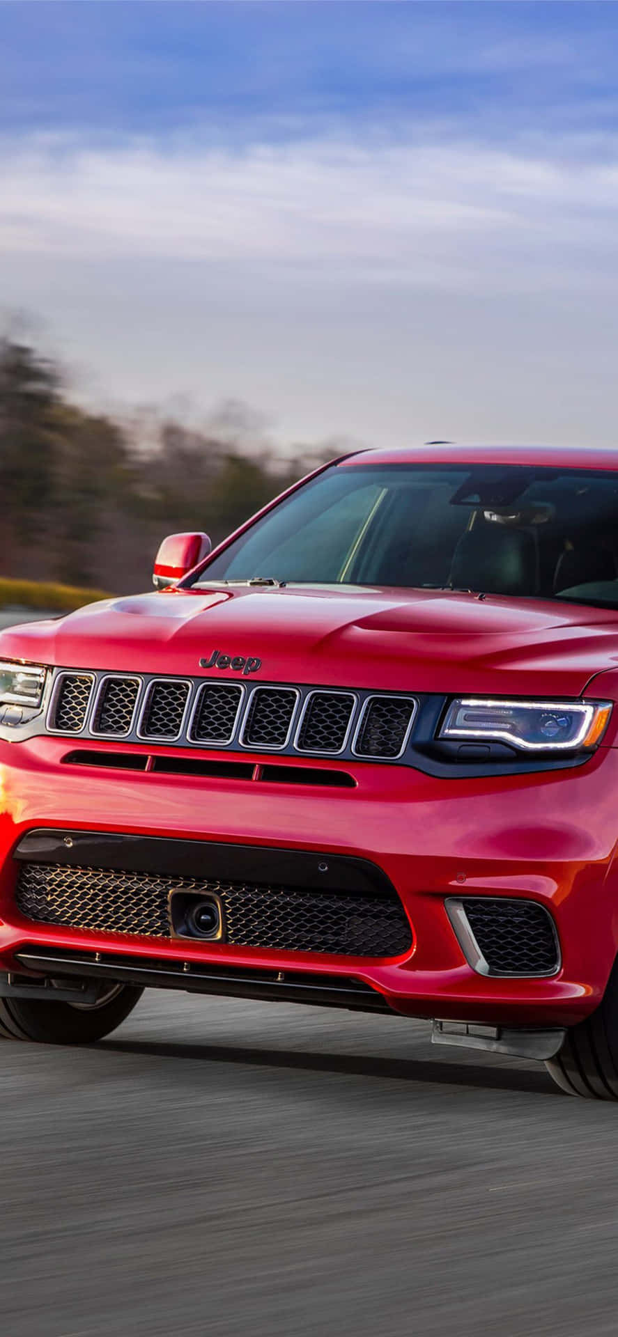 Den røde 2019 Jeep Grand Cherokee kører ned ad vejen. Wallpaper