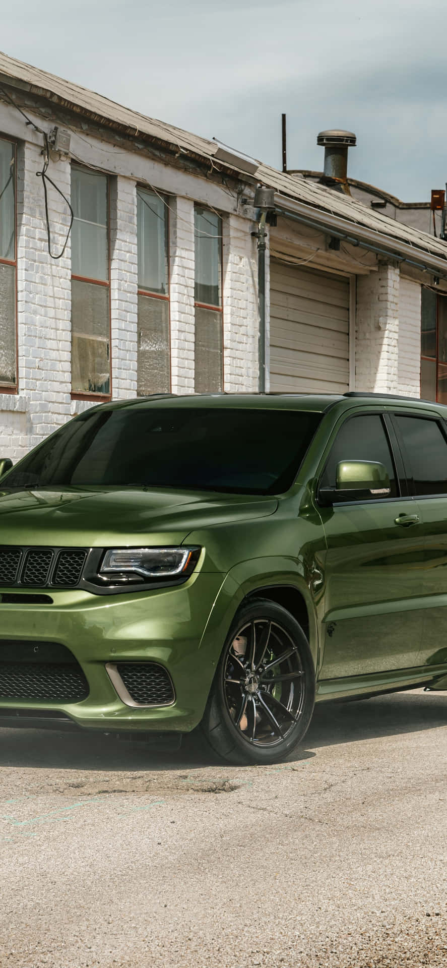 The Green 2019 Jeep Grand Cherokee Is Parked In Front Of A Building Wallpaper