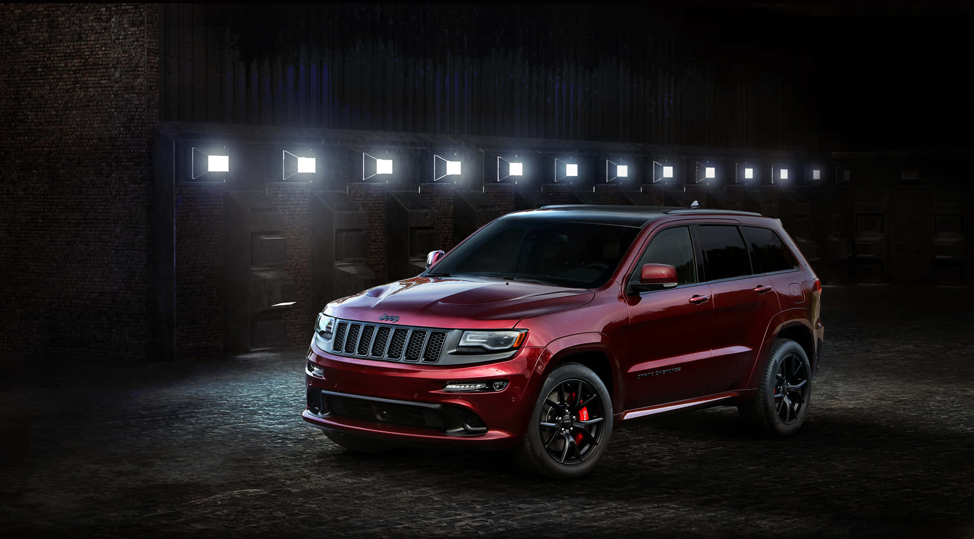 The Red Jeep Grand Cherokee Is Parked In A Dark Room Wallpaper