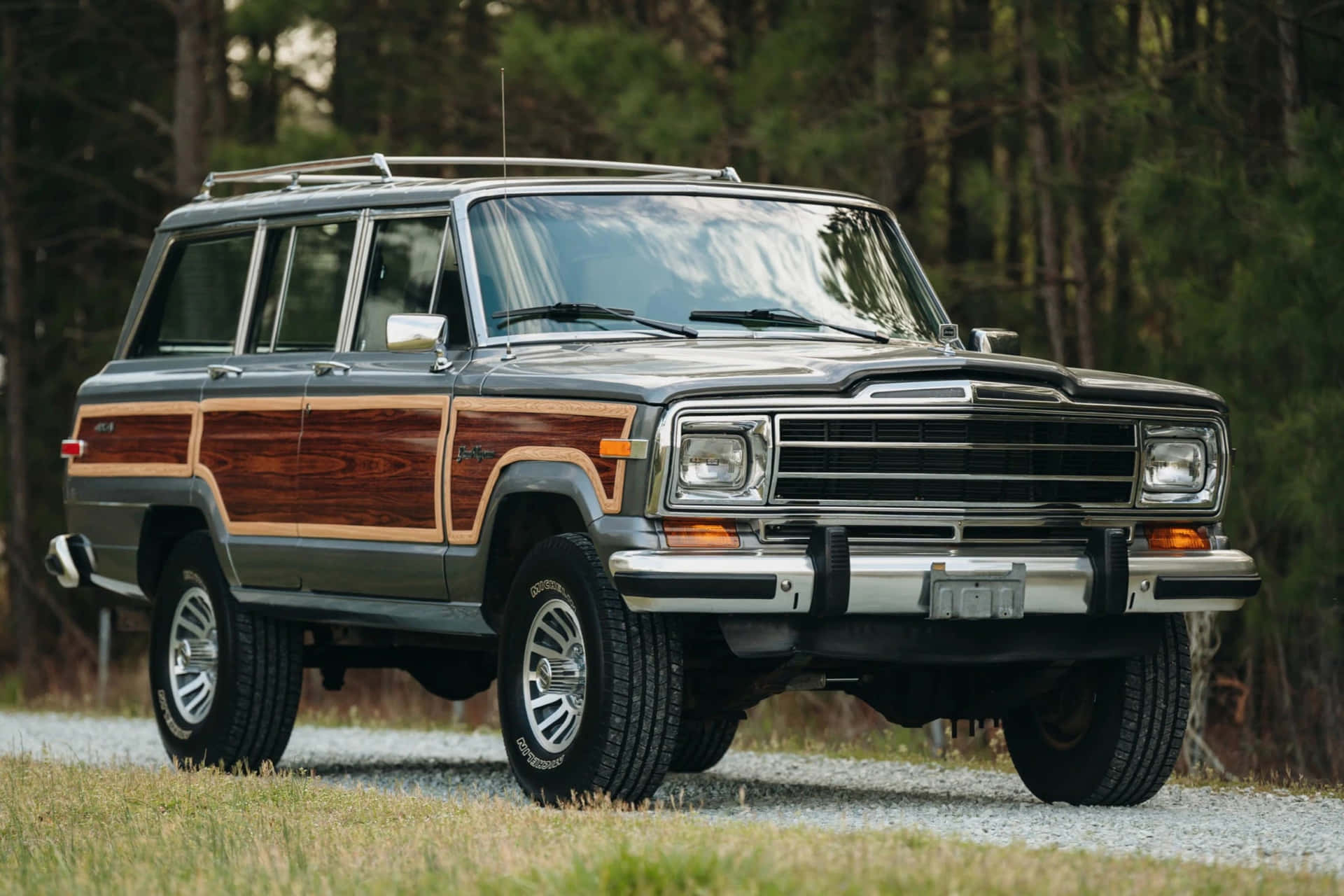 Classic Jeep Wagoneer on a Mountain Road Wallpaper