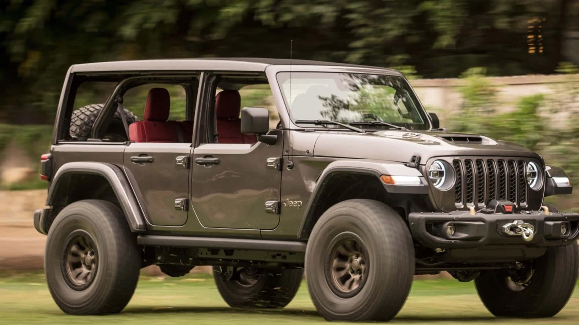 The Jeep Wrangler Is Driving Down The Road