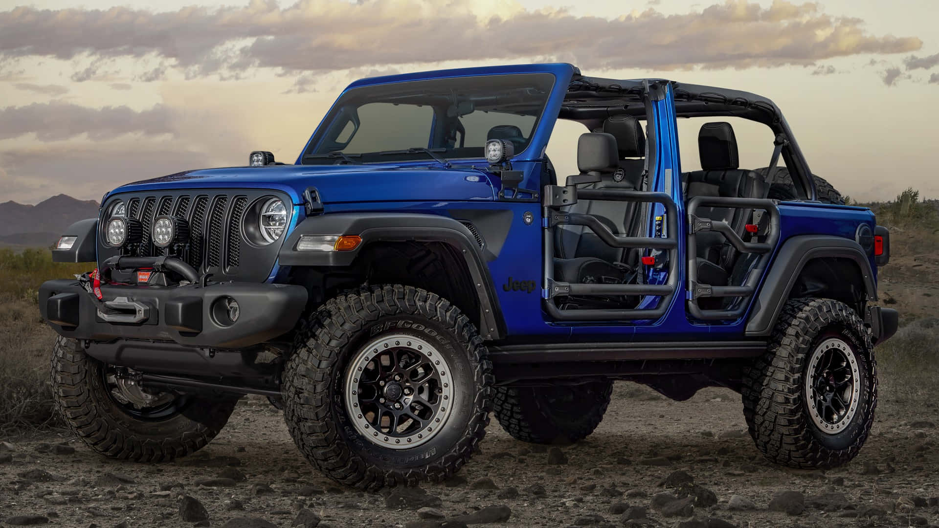 The Blue Jeep Wrangler Is Parked In The Desert