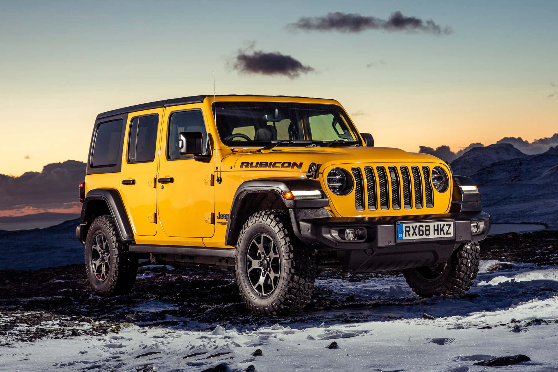 The Jeep Wrangler Is Parked On A Snowy Mountain