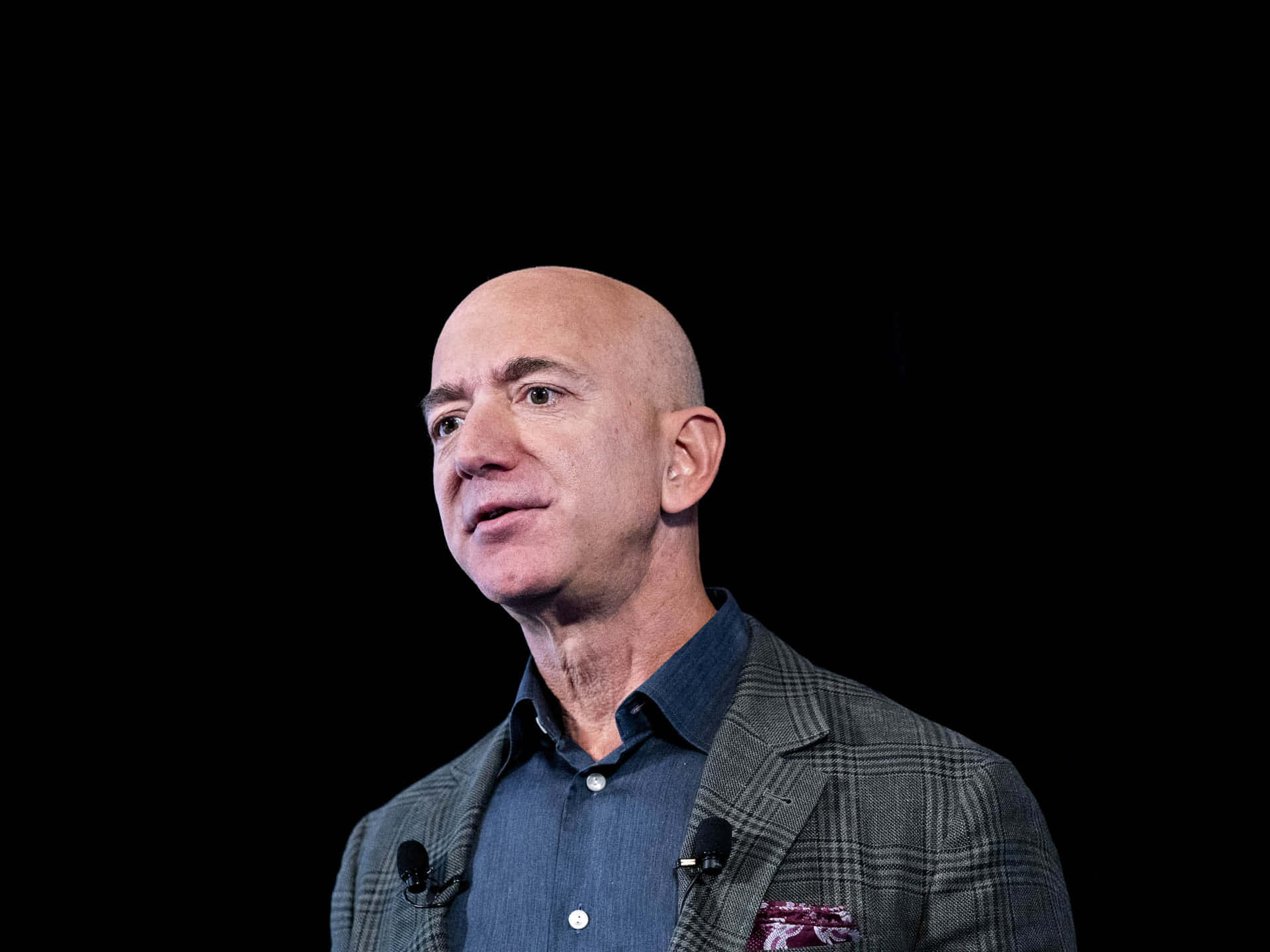 Jeff Bezos standing against an abstract background
