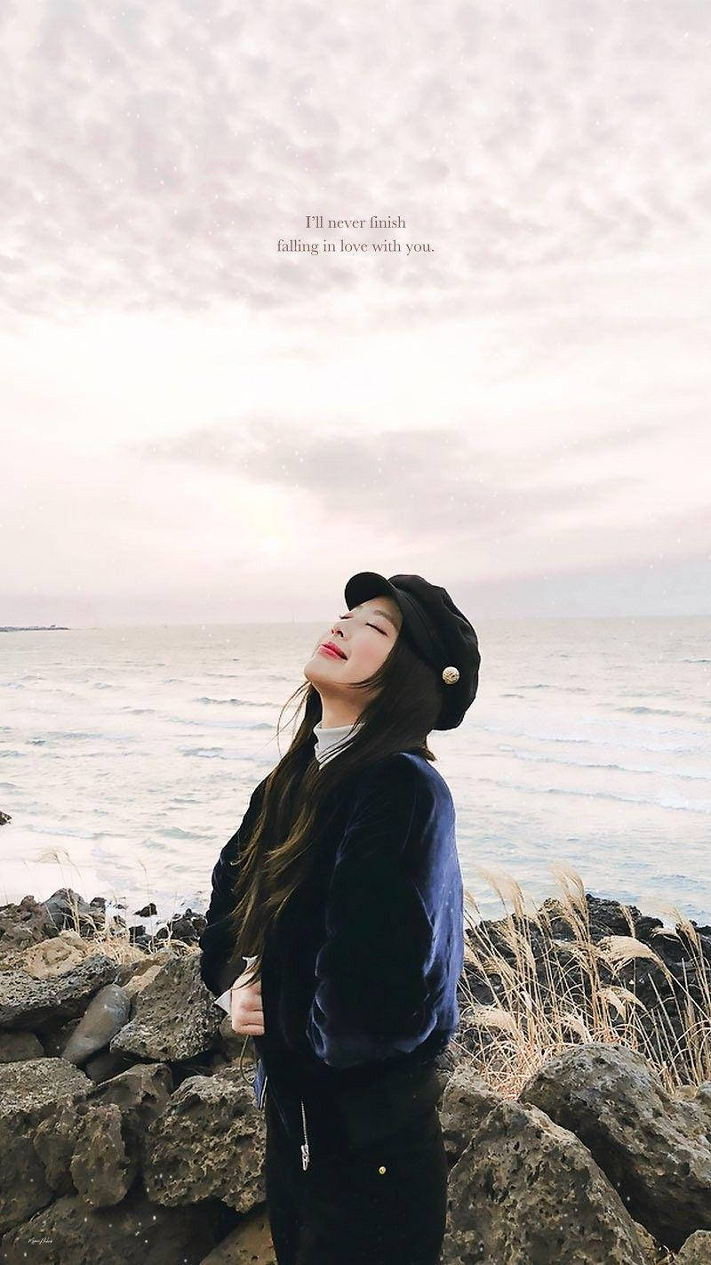 Jennie Kim Su Una Spiaggia Rocciosa Sfondo