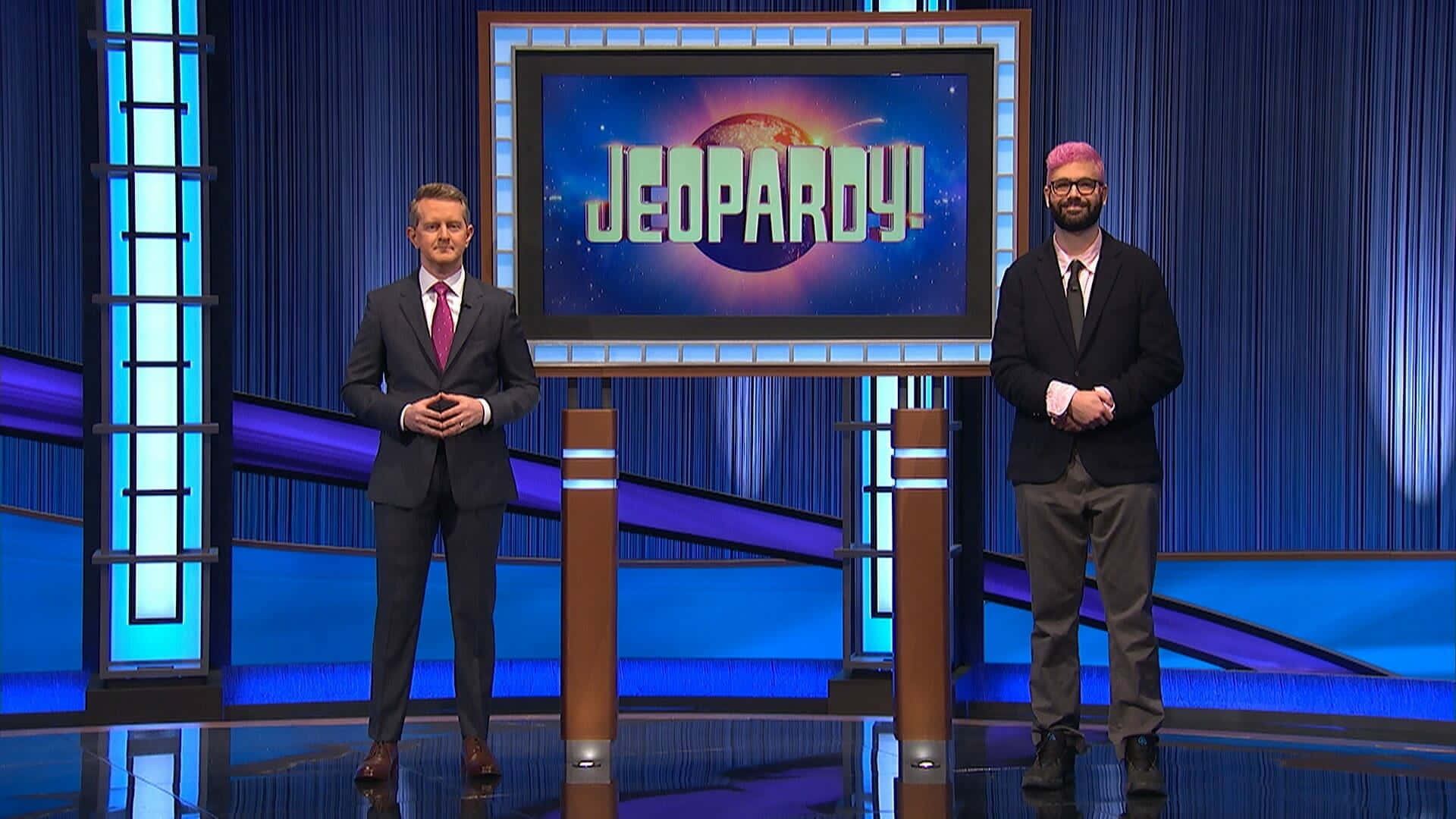 Two Men Standing In Front Of A Jeopardy Tv Set