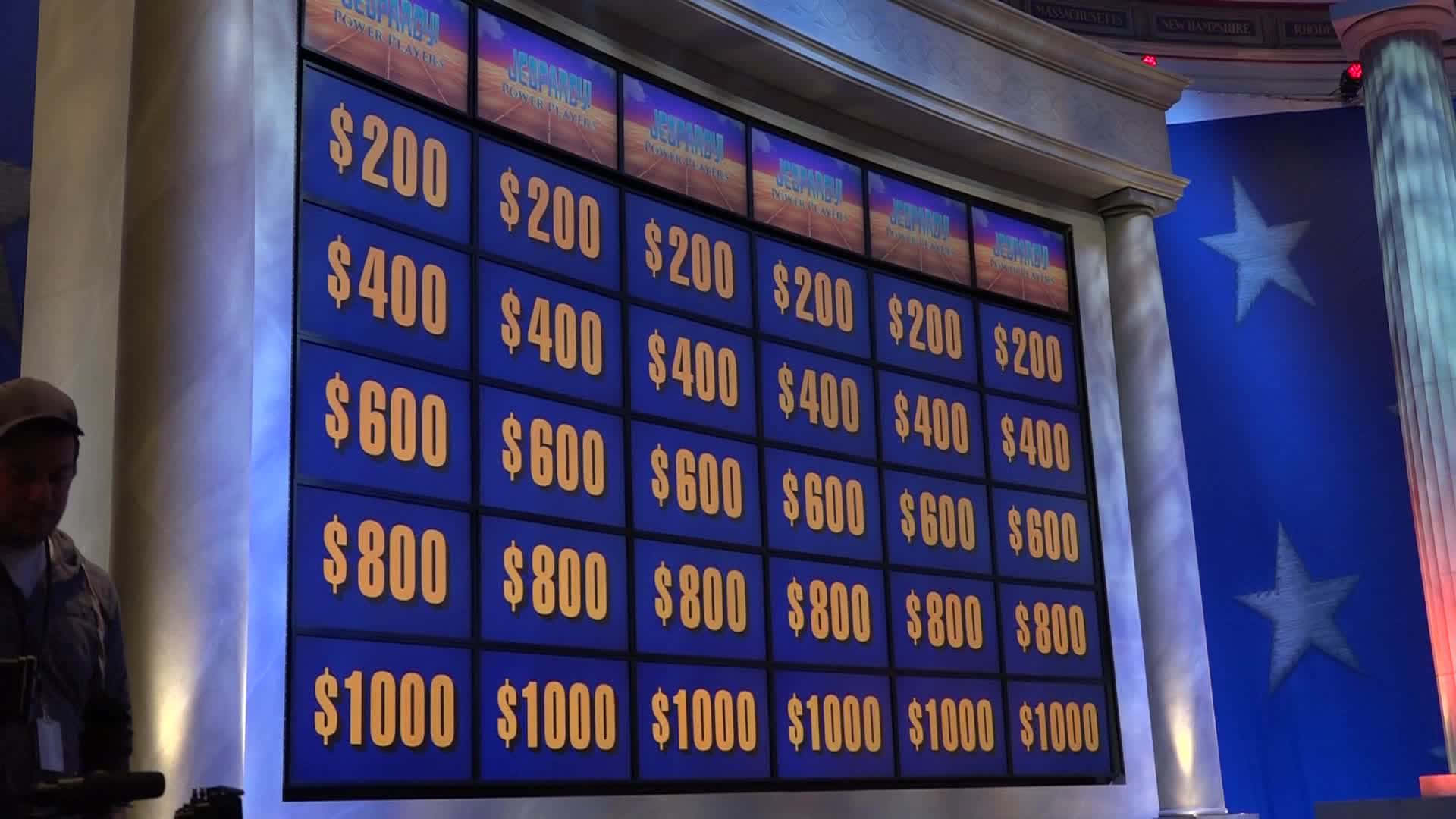 A Man Is Standing In Front Of A Jeopardy Board