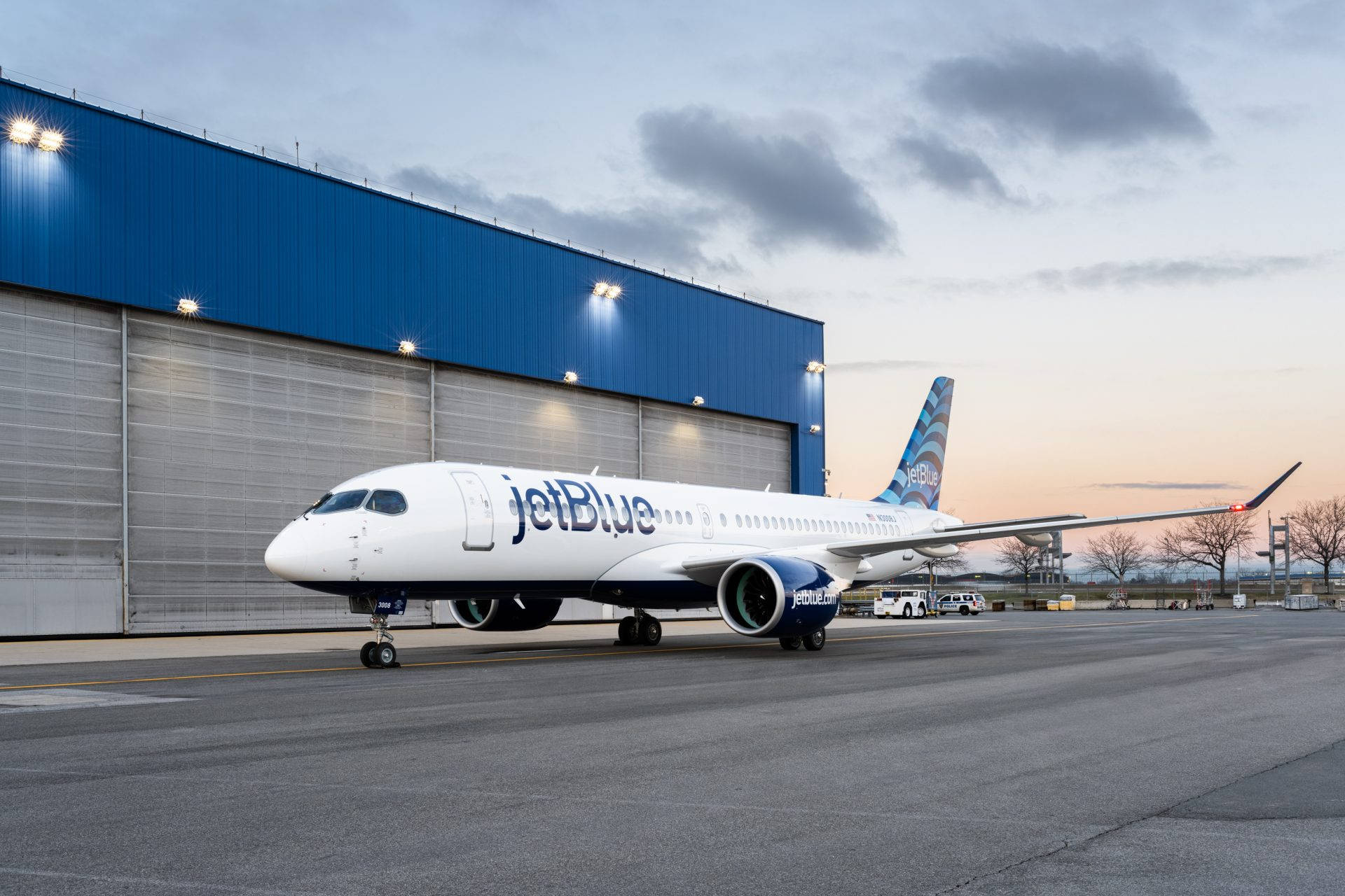 Aviónde Jetblue Airways Junto Al Hangar Del Aeropuerto Fondo de pantalla