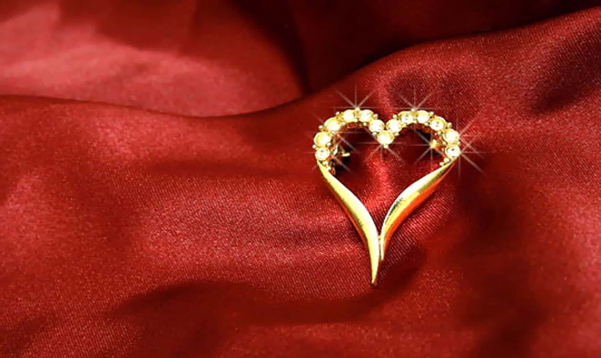 A Gold Heart Shaped Brooch On A Red Cloth