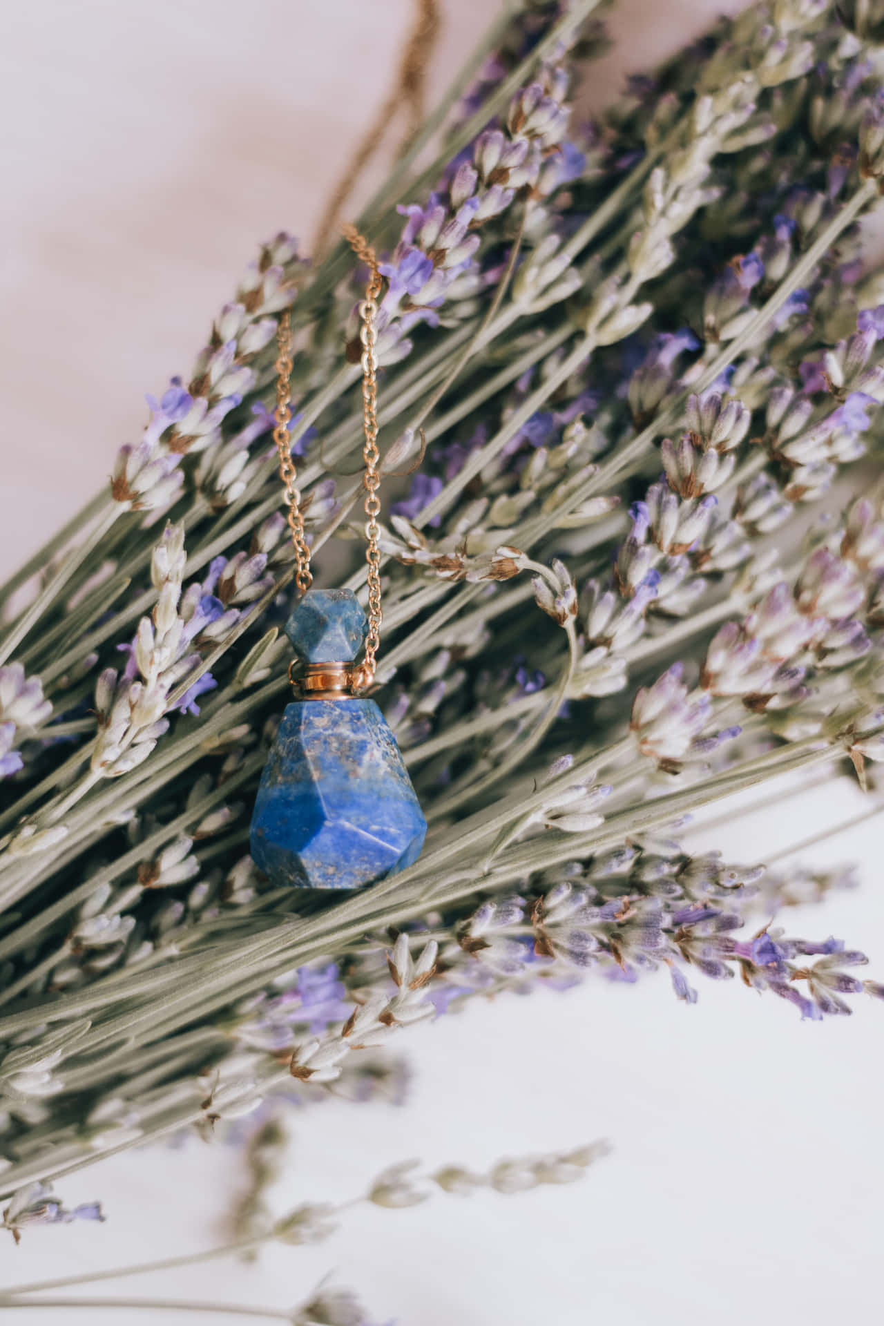 A Blue Stone Pendant With Lavender Flowers