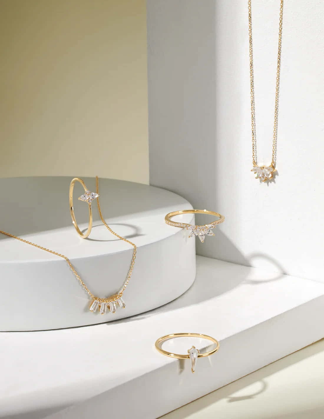 A Gold Necklace, Earrings, And Bracelet On A White Table