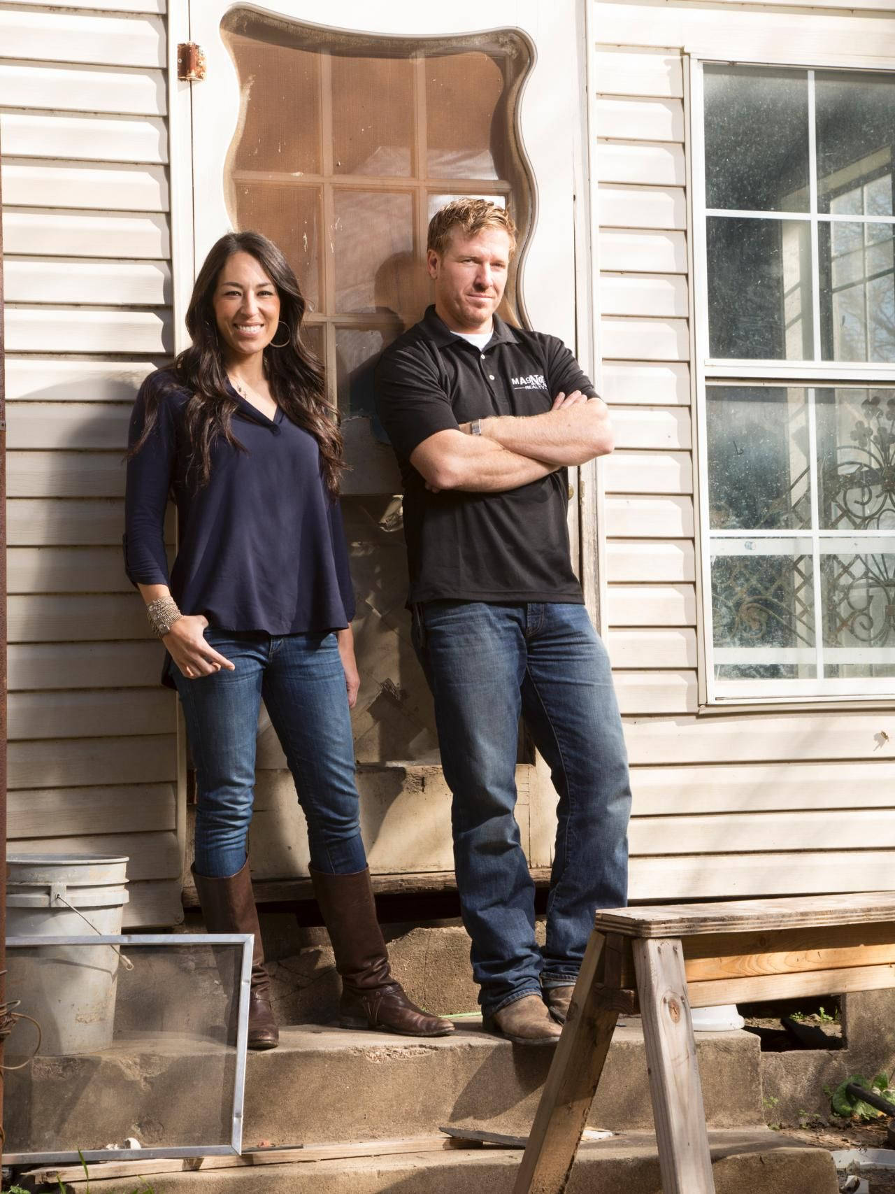Joanna and Chip Gaines standing in front of their iconic Farmhouse Wallpaper