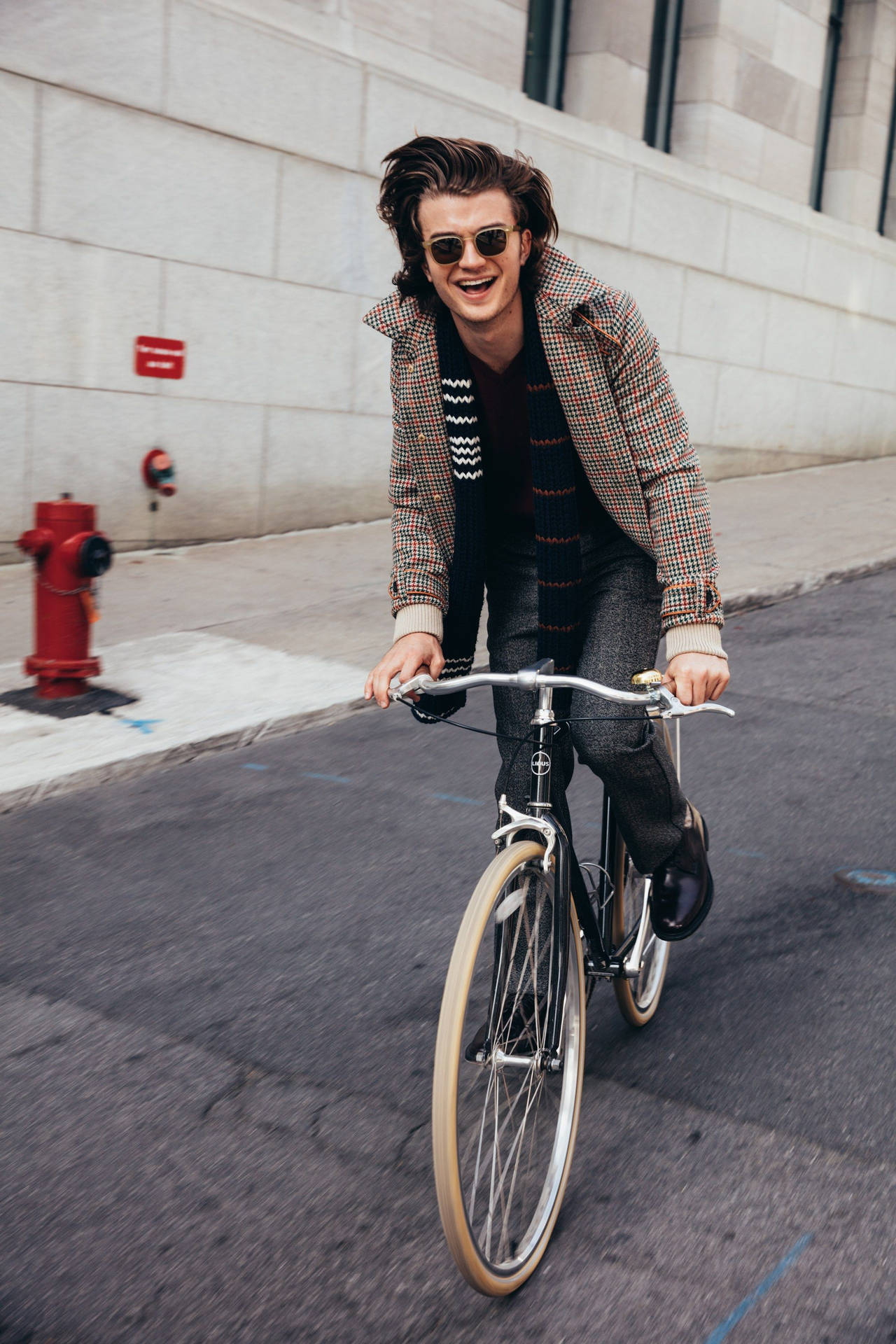 Joe Keery Riding a Bike Wallpaper