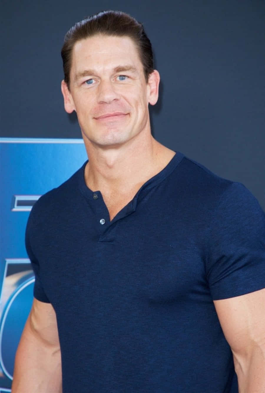 John Cena confidently posing at a WWE event against a dramatic background