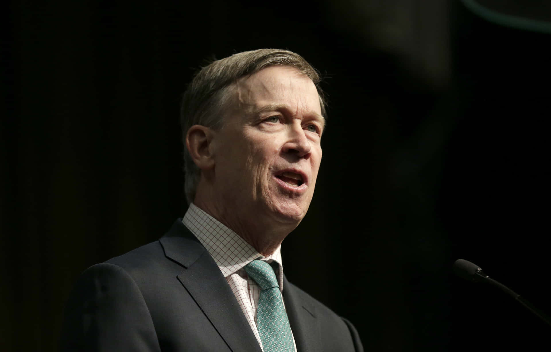 John Hickenlooper Looking Towards Right With Black Background Wallpaper