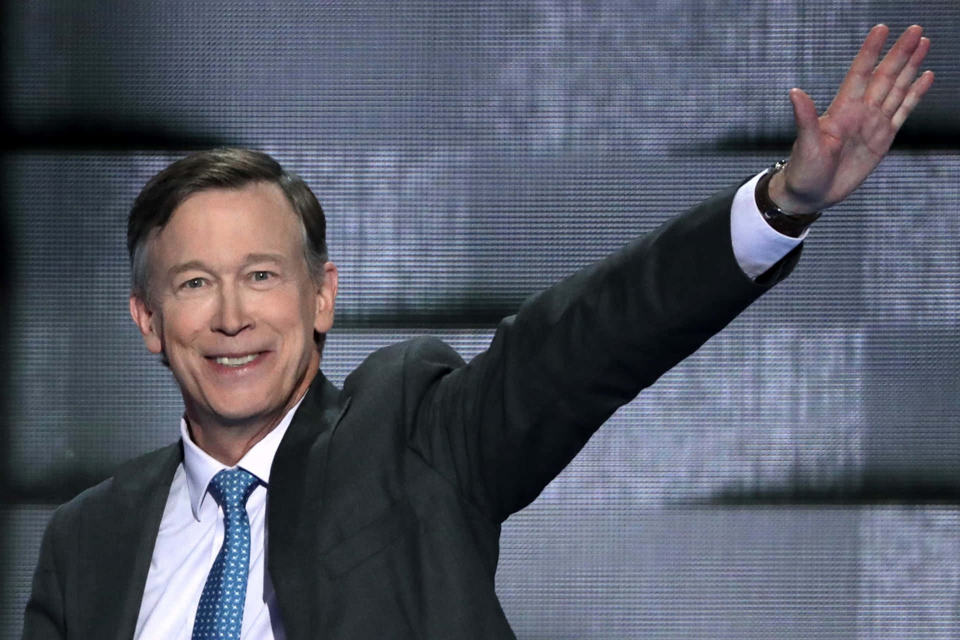 John Hickenlooper Waving With A Gray Background Wallpaper