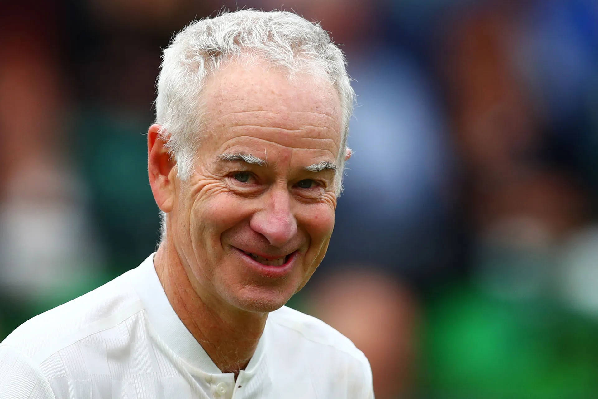John McEnroe Smiling Broadly in a Casual Moment Wallpaper