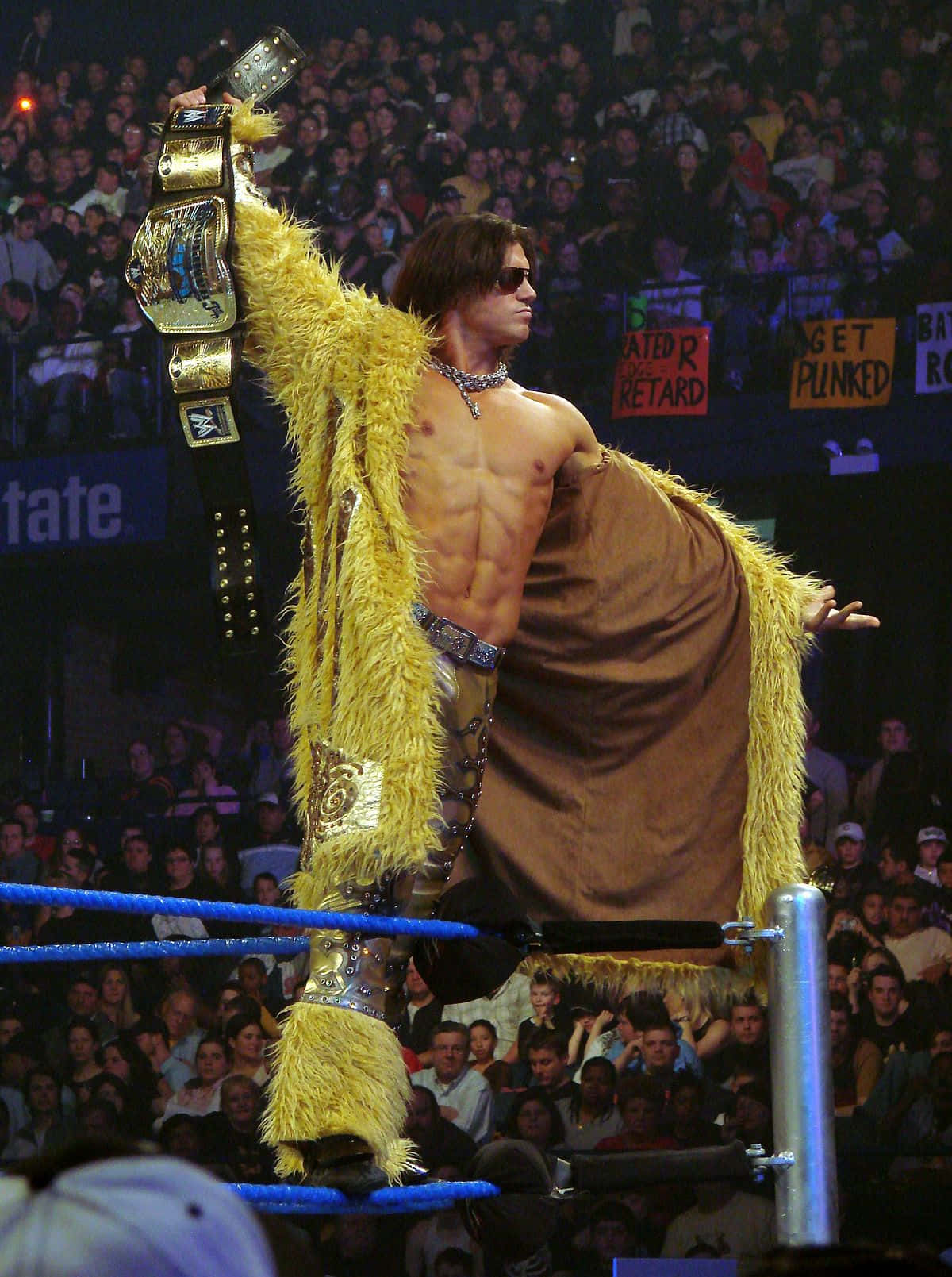 John Morrison displaying his WWE championship belt, clad in a flashy yellow coat. Wallpaper