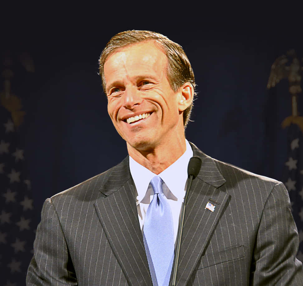 Johnthune Med Brett Leende (this Would Be A Suitable Title For A Wallpaper Featuring A Photo Of John Thune With A Wide Smile). Wallpaper
