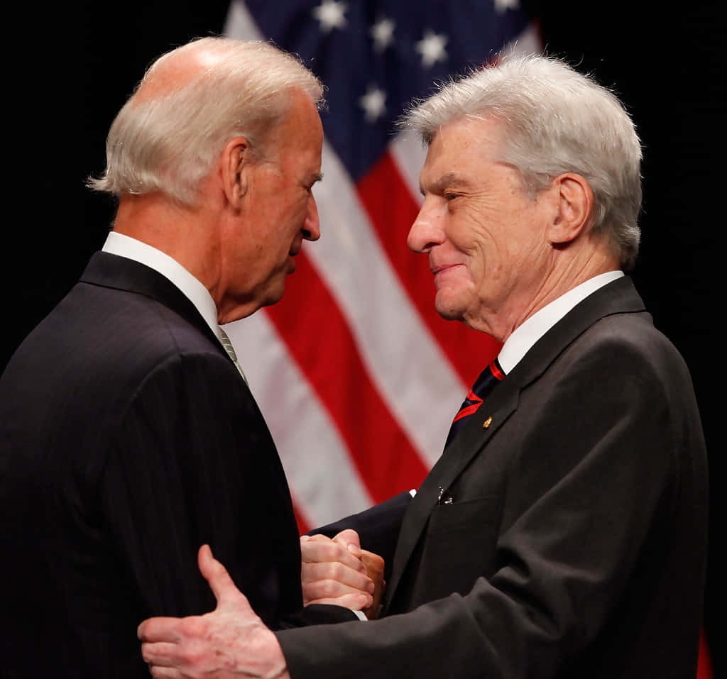 John Warner og Joe Biden med amerikansk flag tapet Wallpaper