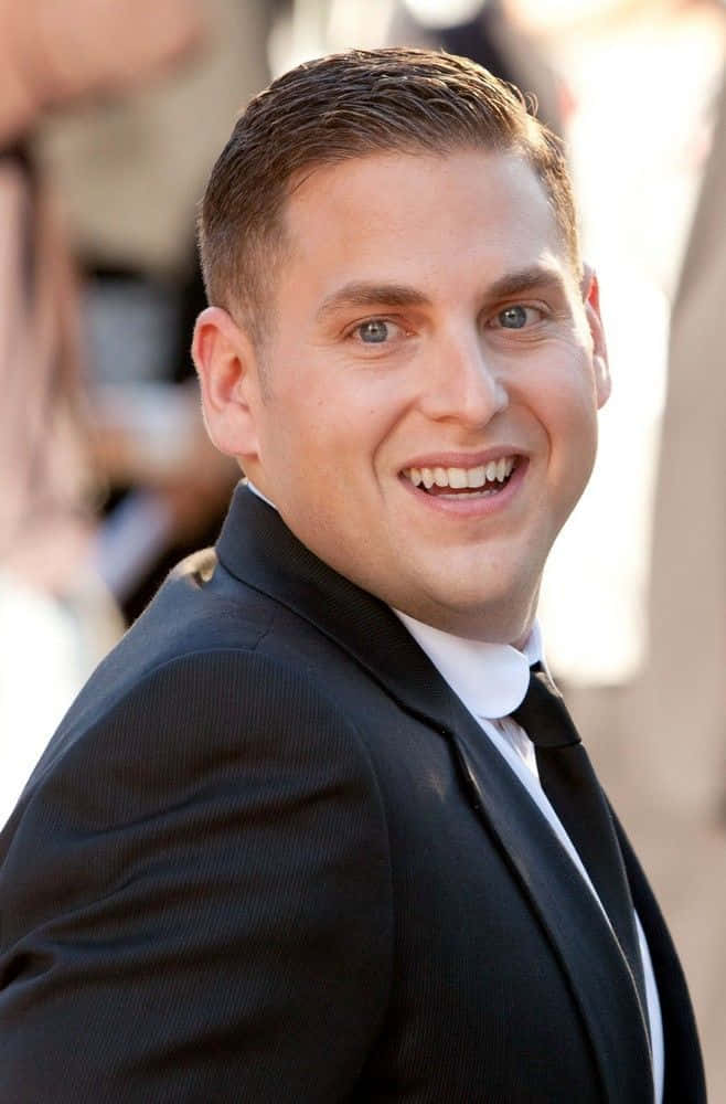 Jonah Hill posing in a slick attire Wallpaper