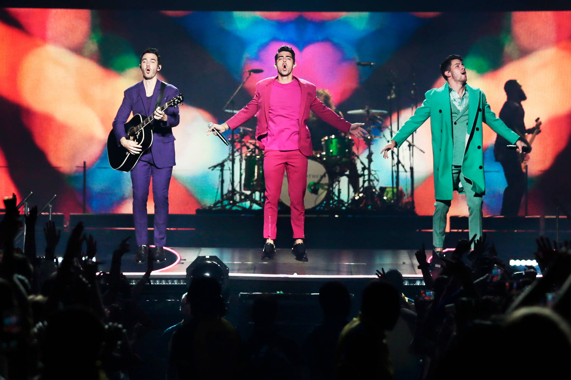 Jonas Brothers In Colorful Outfits Background